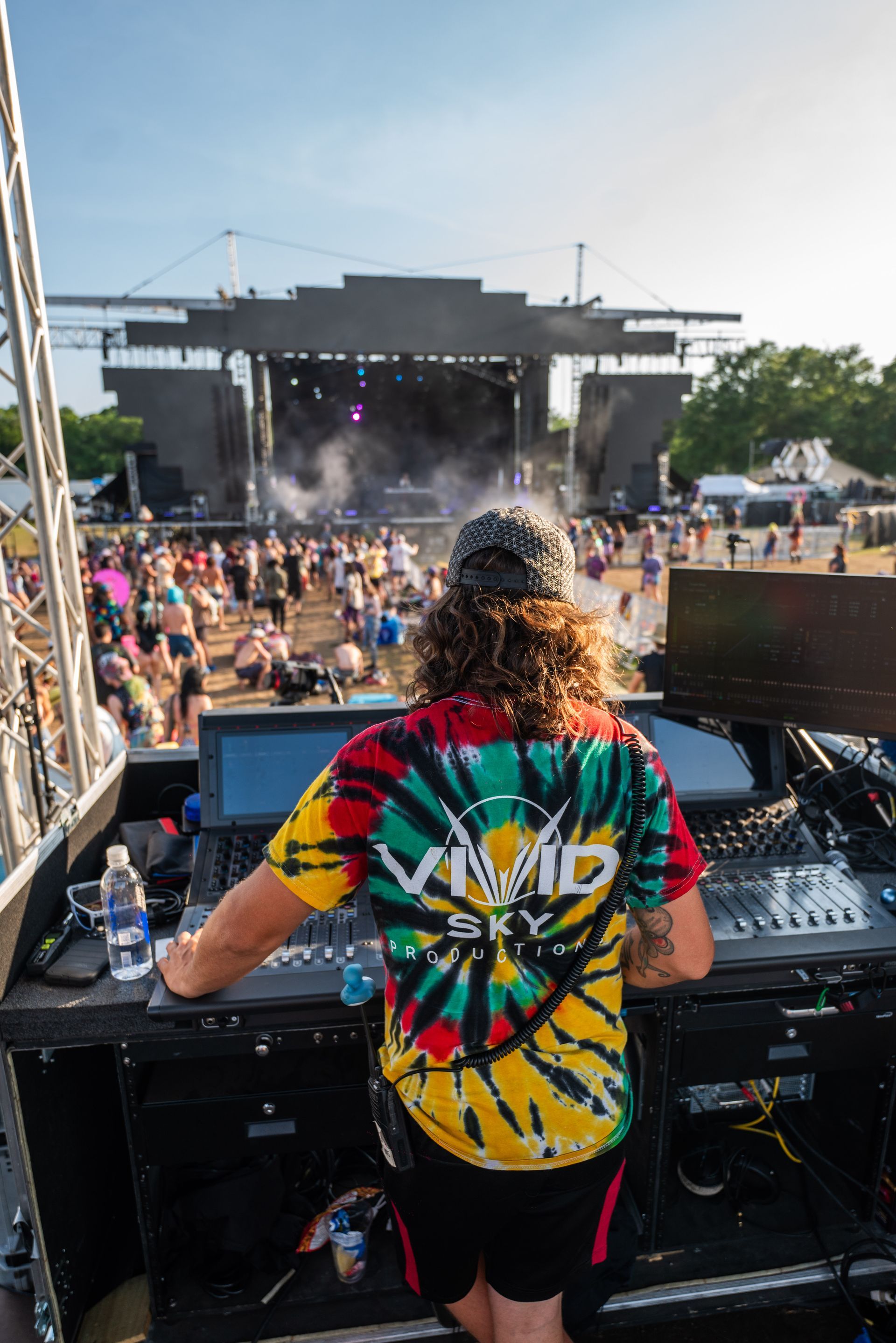 A man in a tie dye shirt is standing in front of a crowd at a concert.