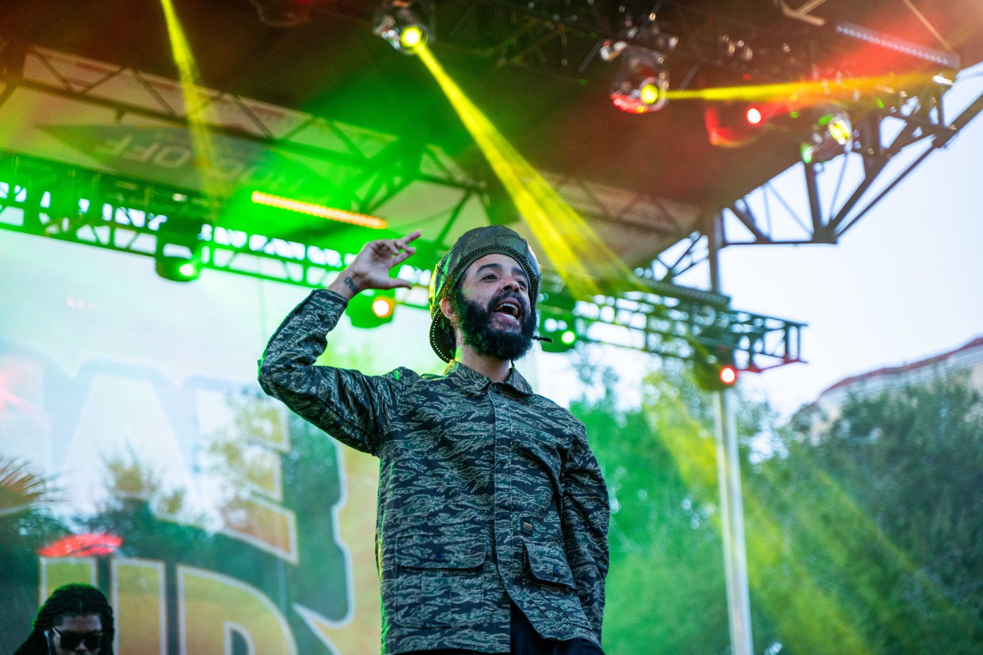 A man with a beard is singing on a stage at a concert.