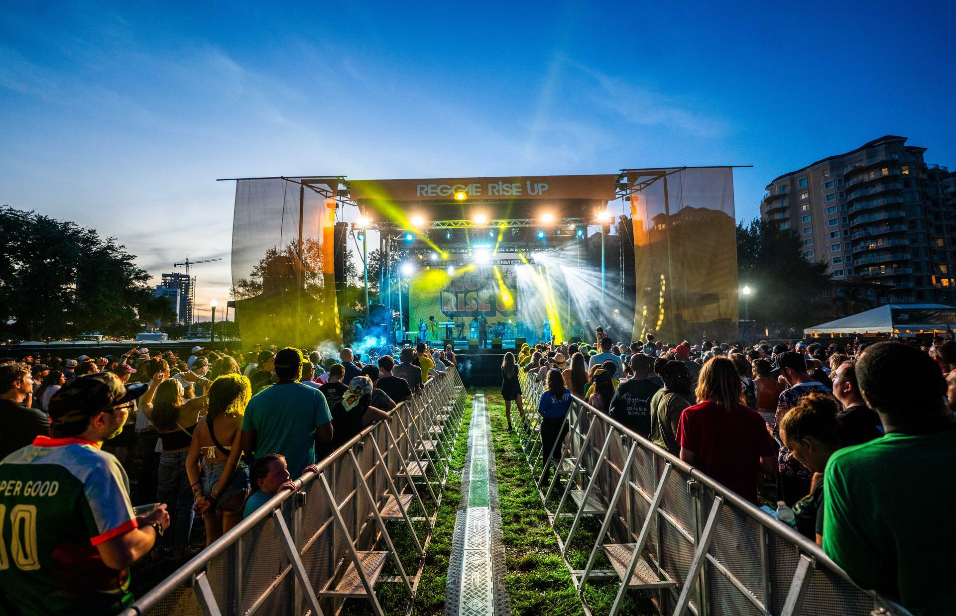 A crowd of people are standing in front of a stage at a concert.