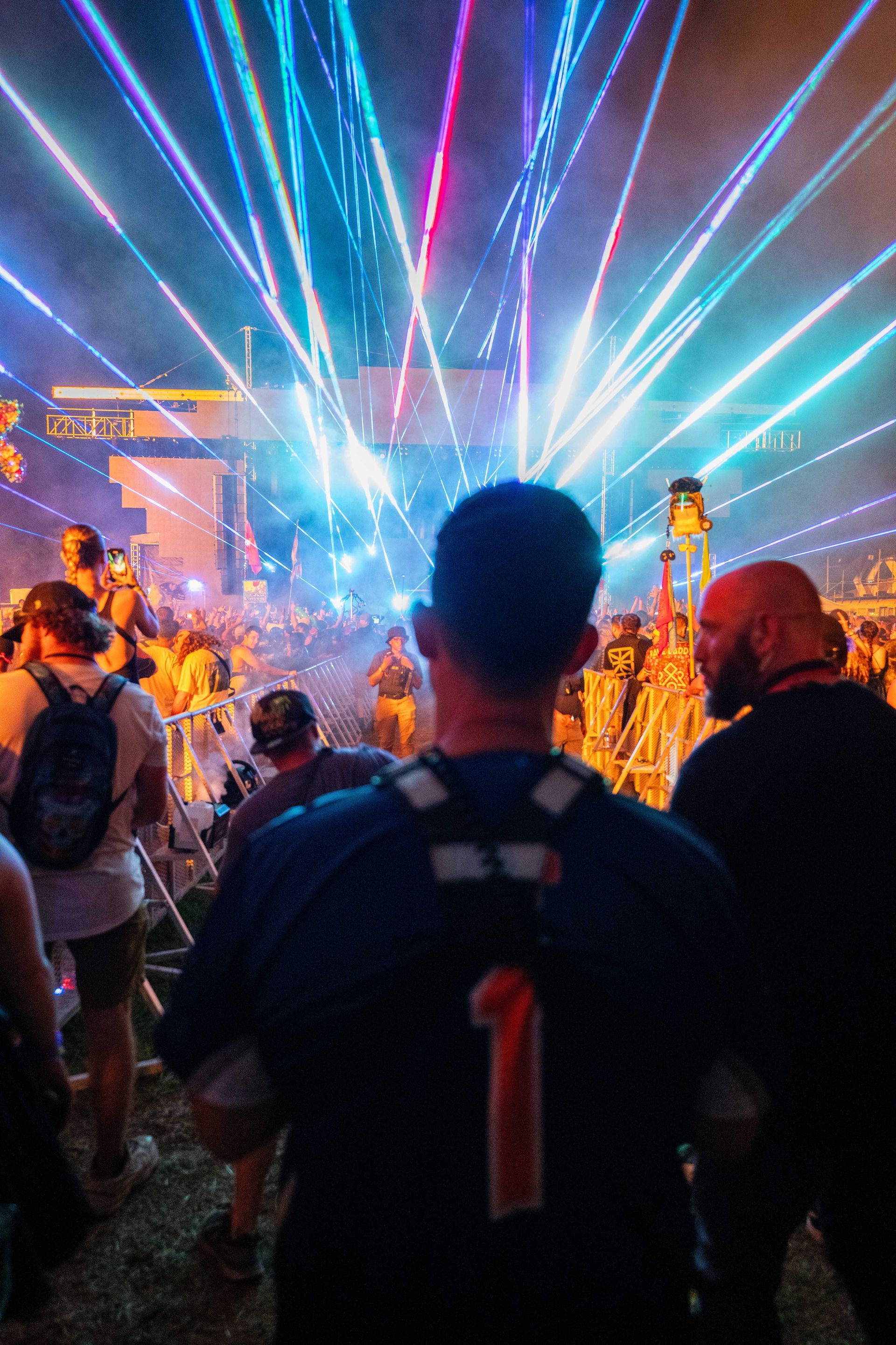 A man is standing in front of a crowd of people watching a fireworks display.