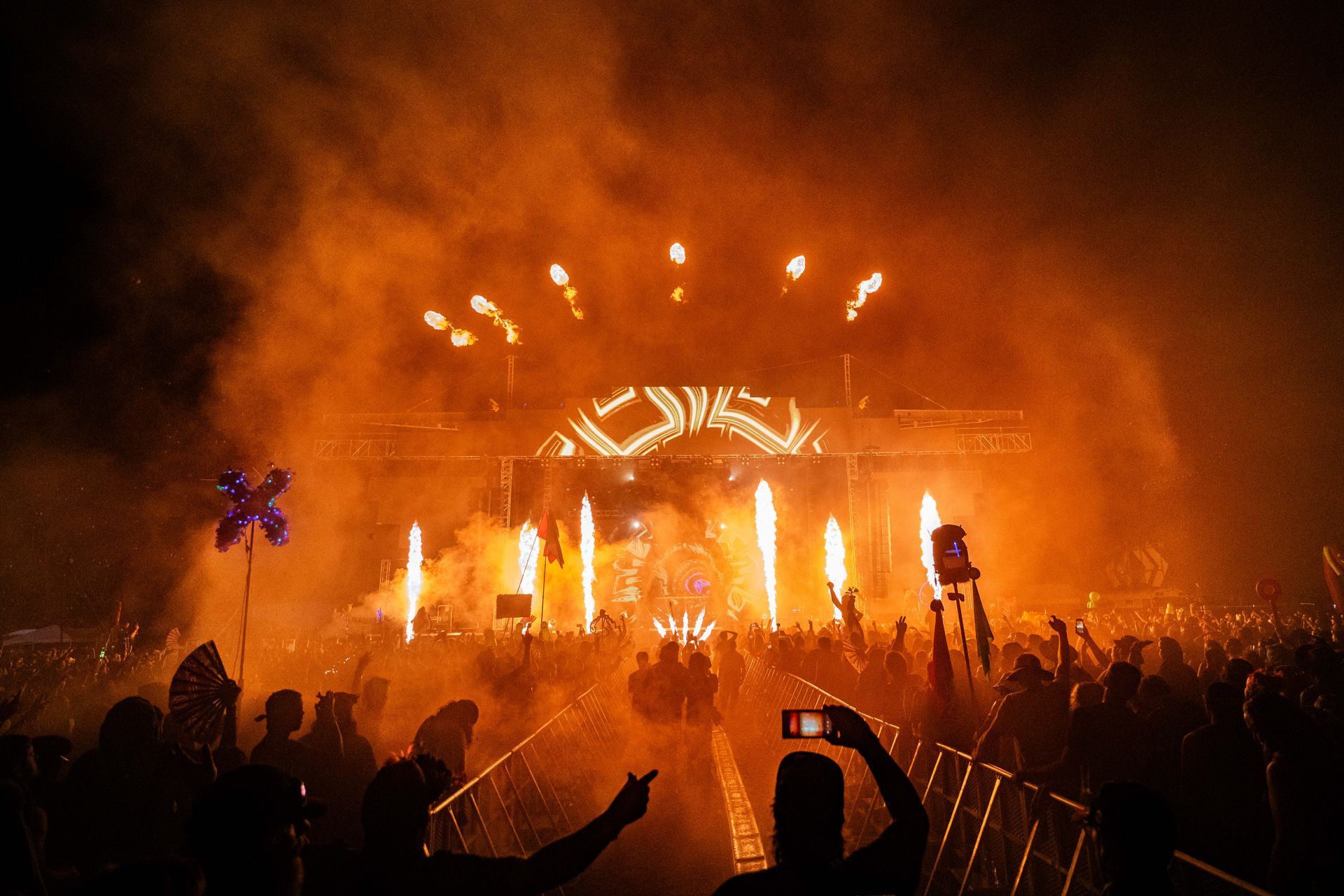 A crowd of people are standing in front of a stage at a concert.