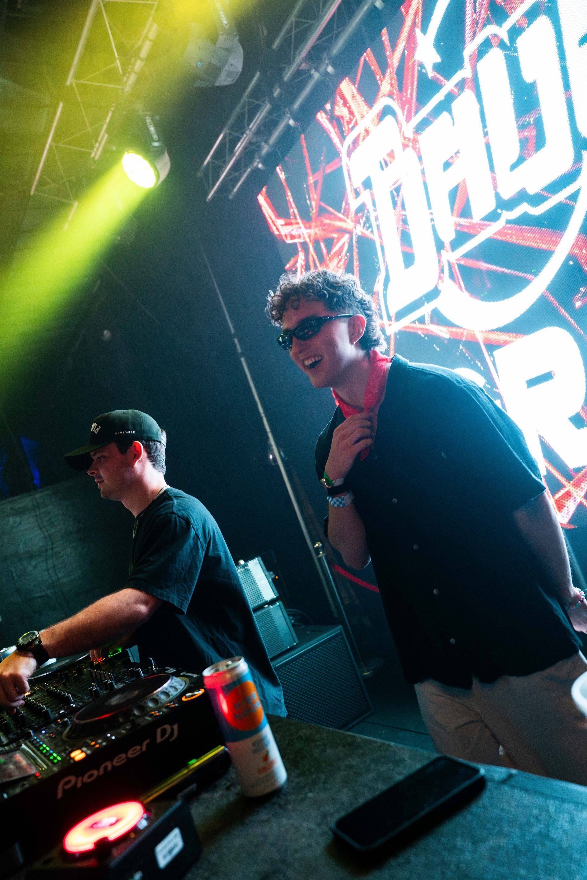 Two men are playing music on a stage in a club.
