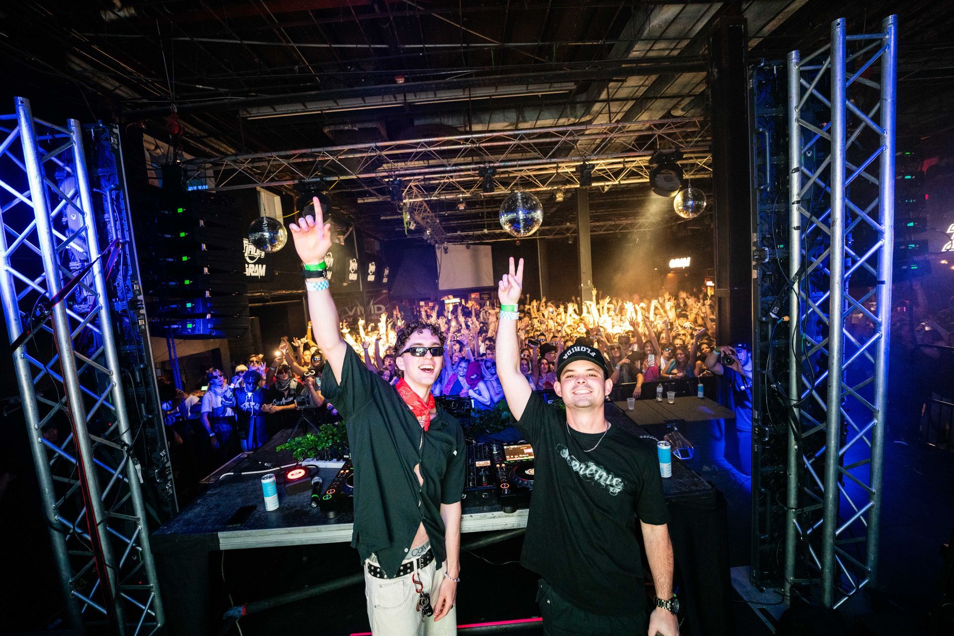 Two men are standing in front of a crowd at a concert.