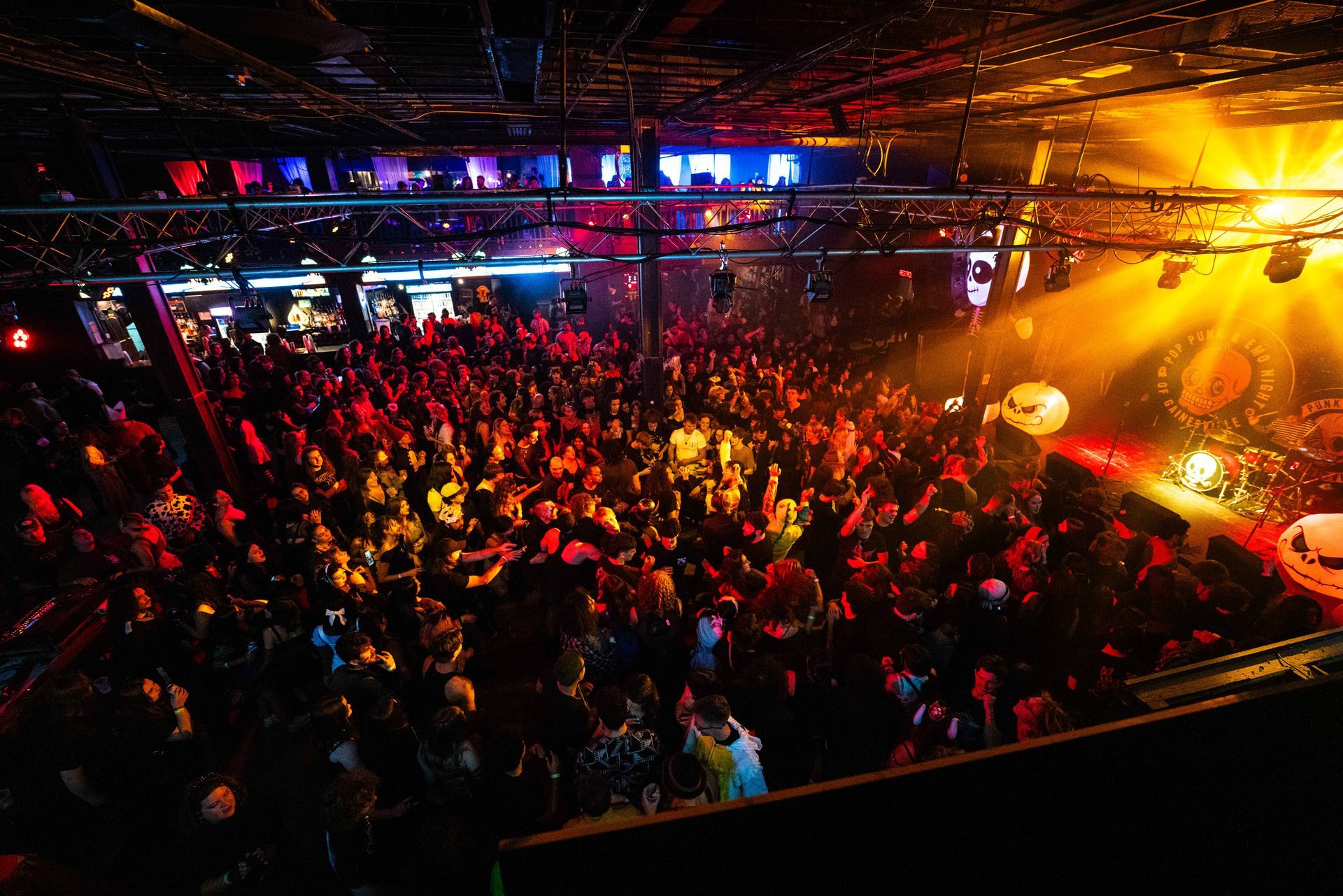 A large crowd of people are watching a band on stage at a concert.