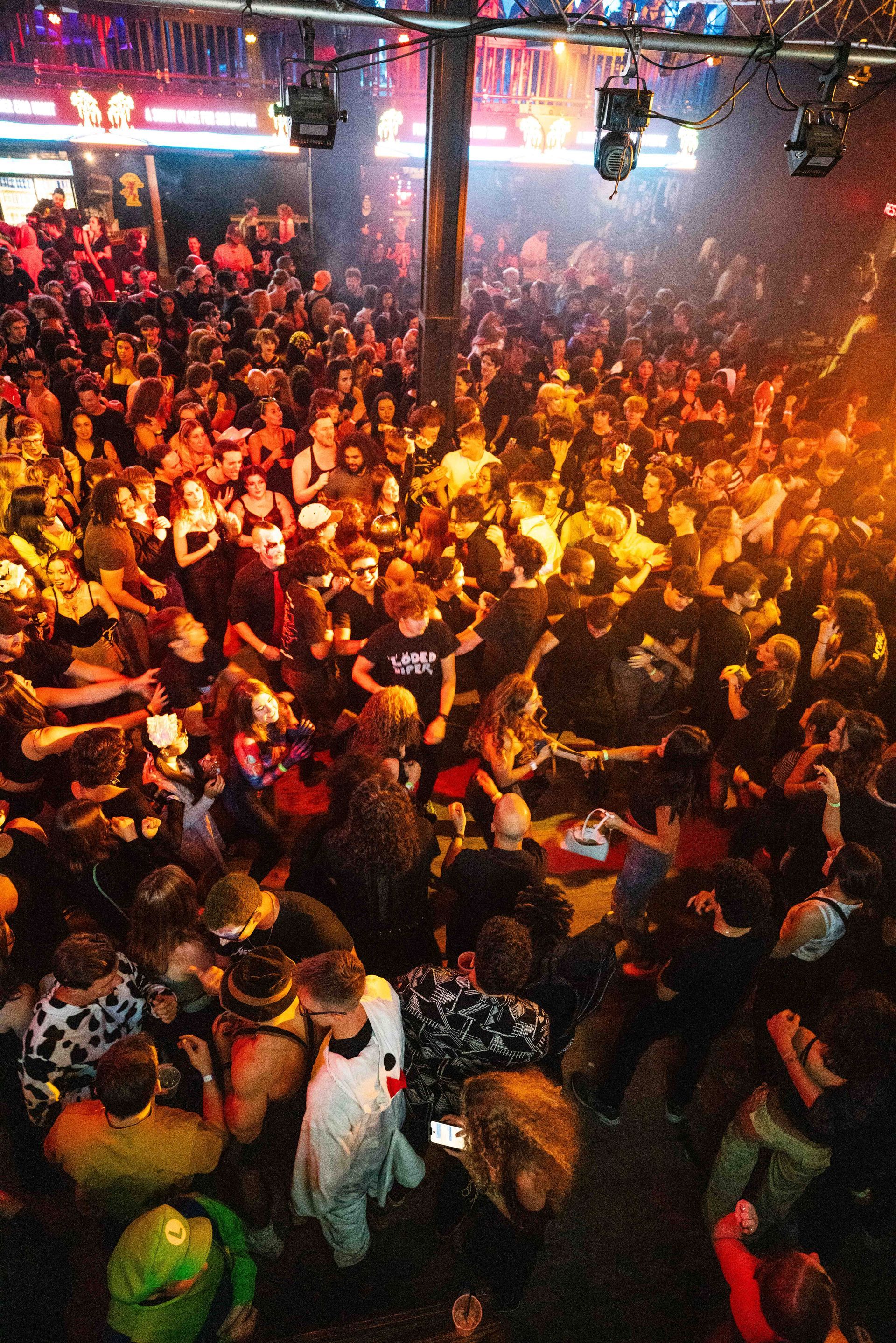 A large crowd of people are gathered in a club.