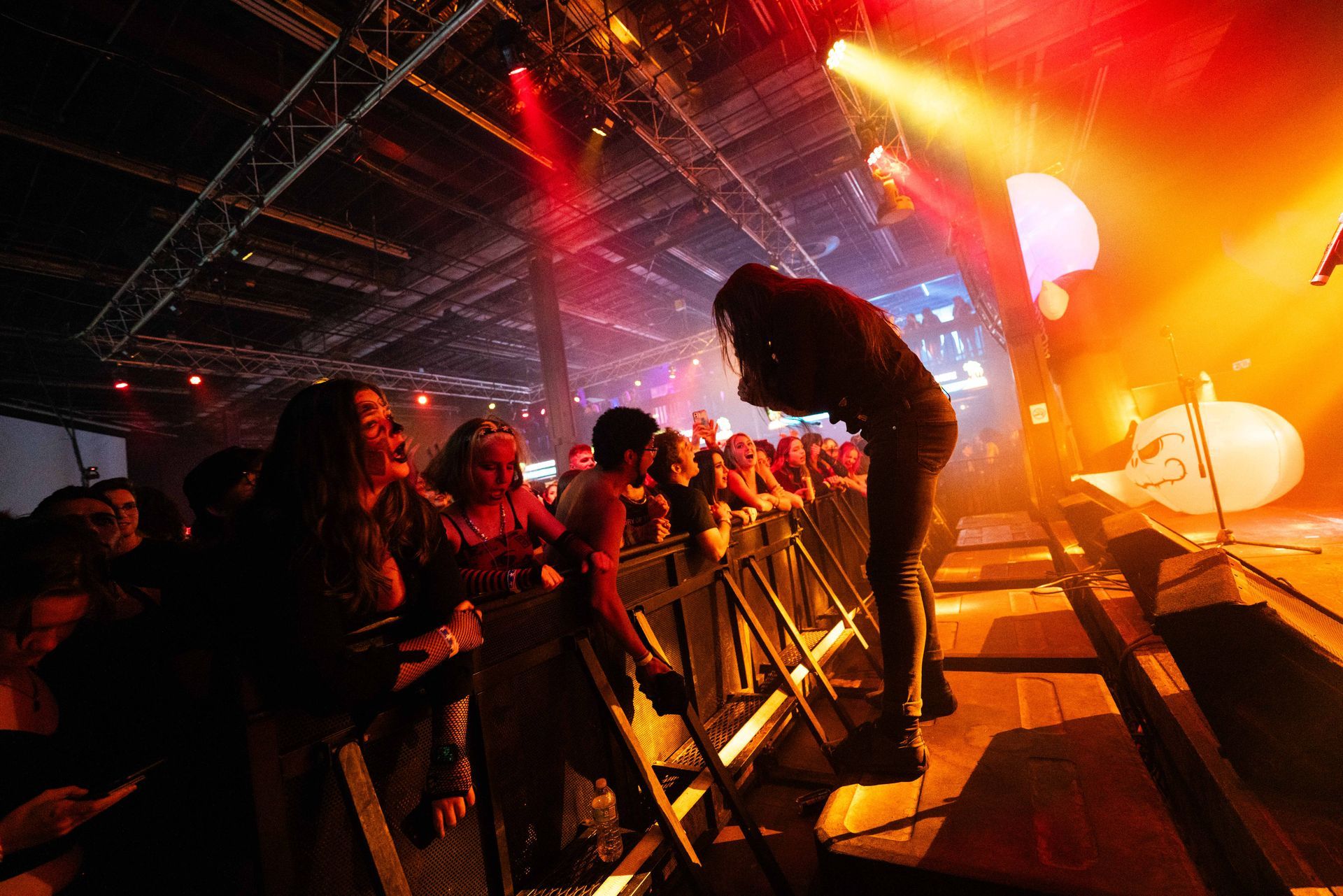 A man is standing on a stage in front of a crowd at a concert.