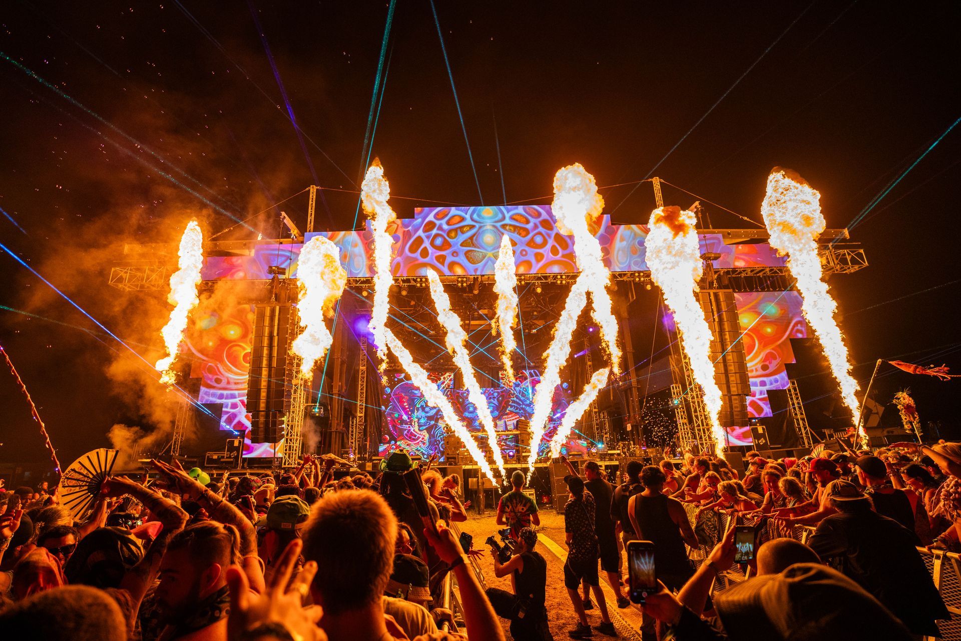 A crowd of people are watching fireworks at a concert.