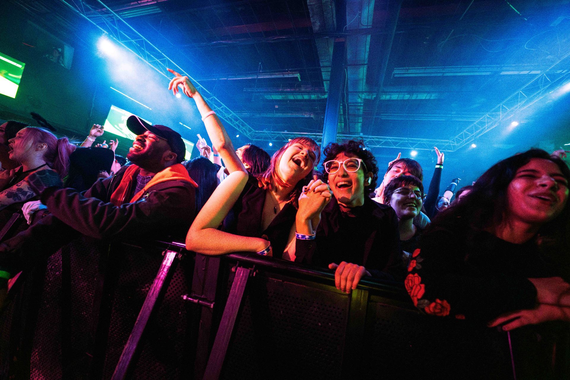 A crowd of people are watching a concert in a dark room.