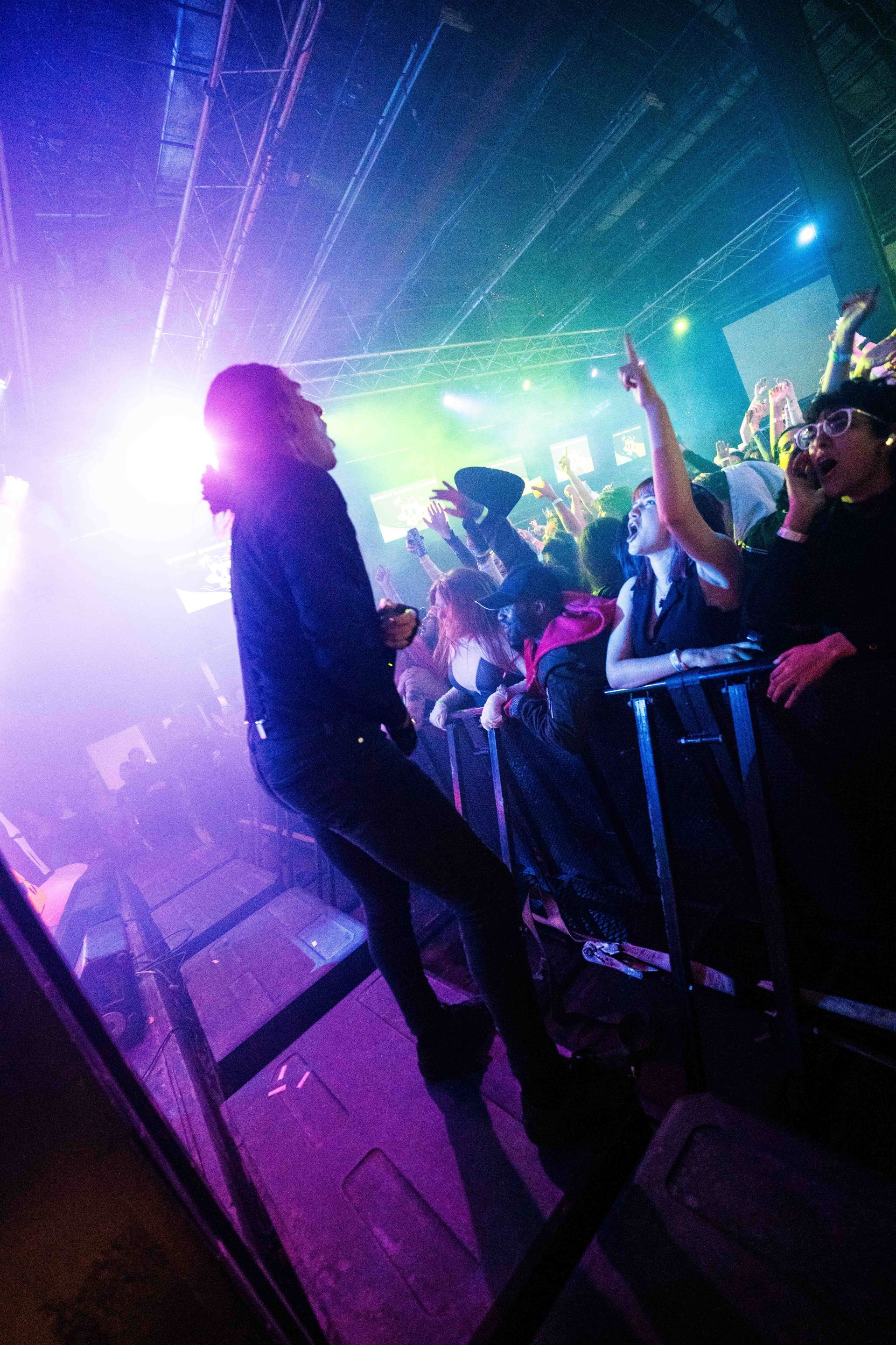 A man is singing into a microphone in front of a crowd at a concert.