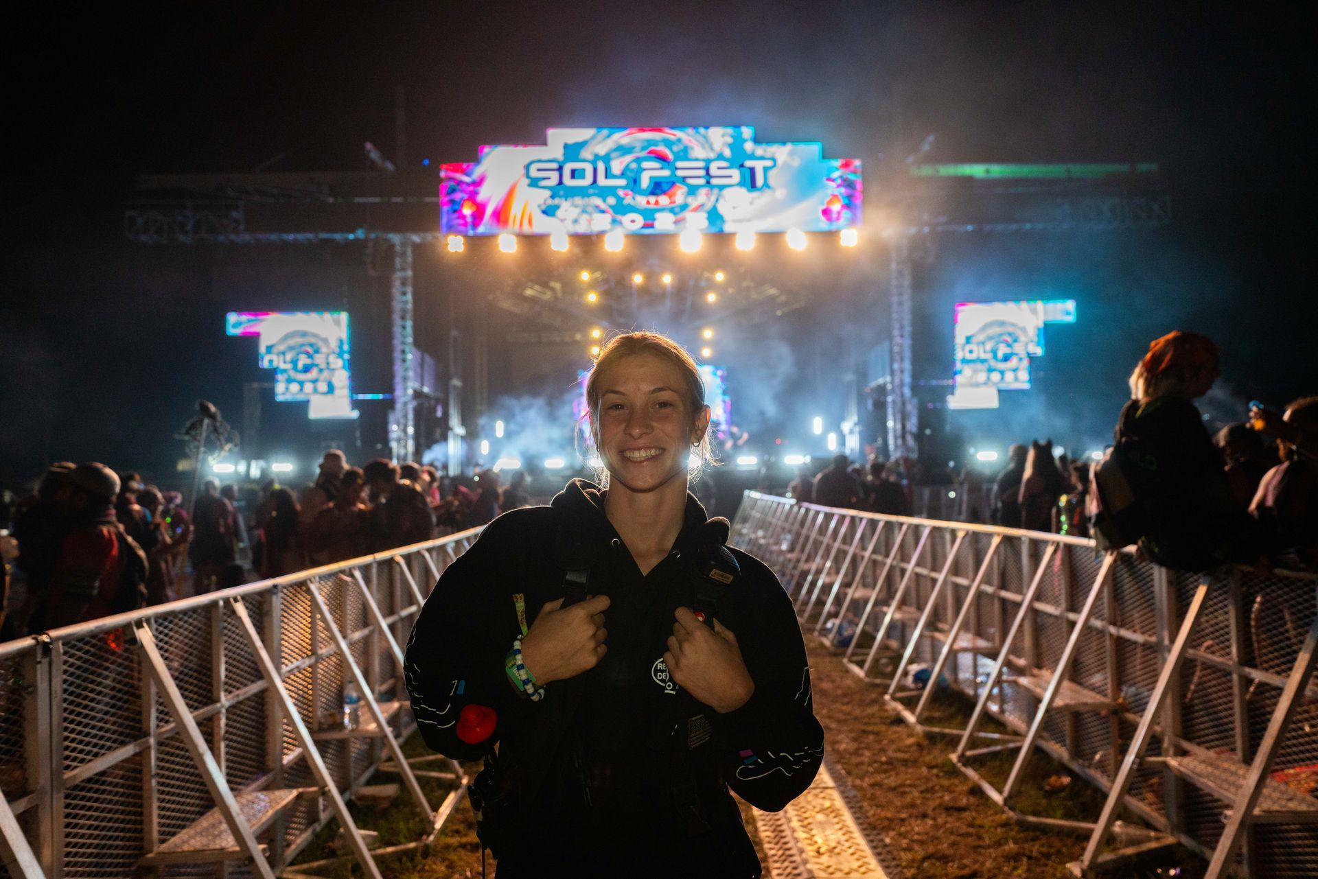 A man is standing in front of a stage at a concert.