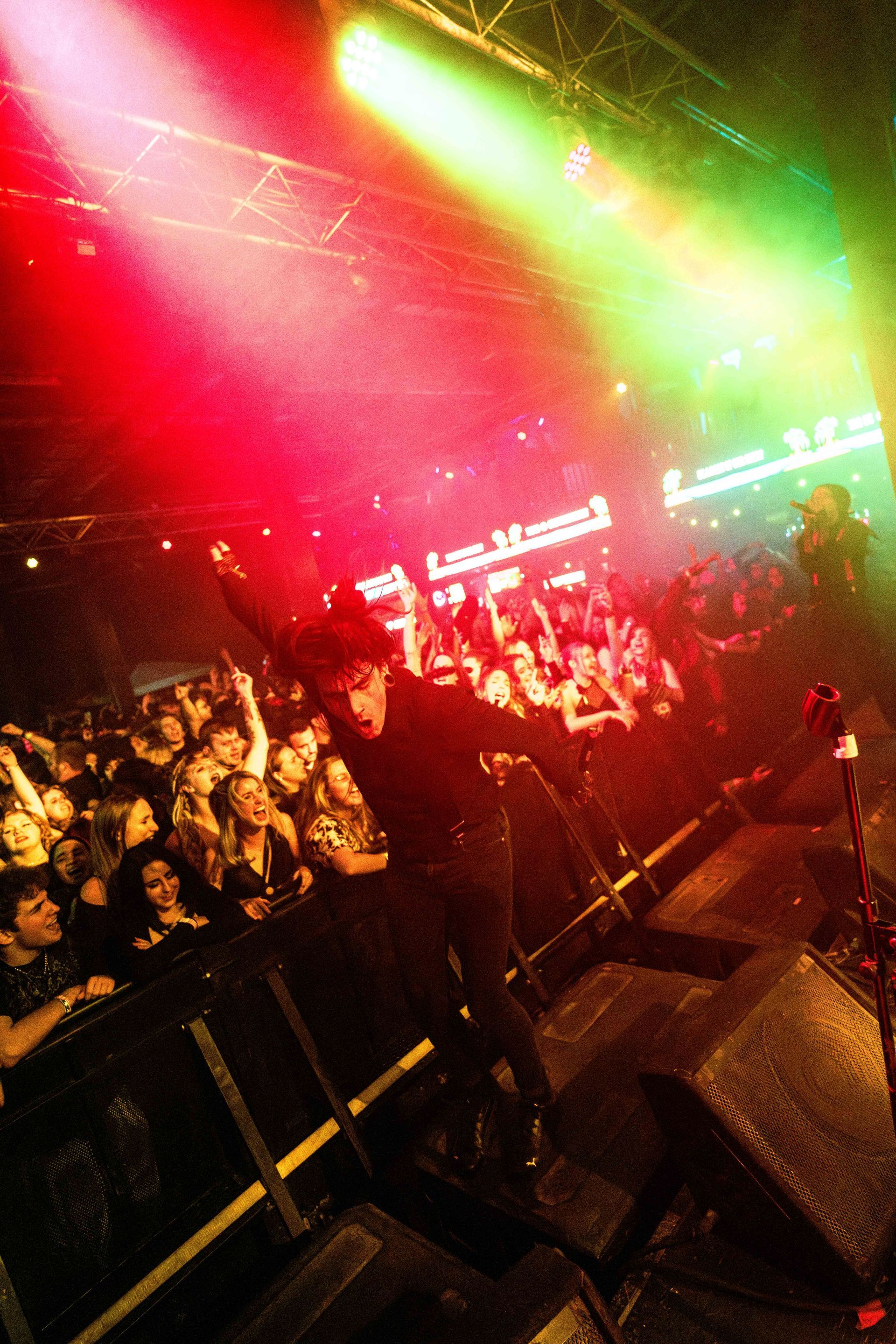 A man stands on stage in front of a crowd at a concert