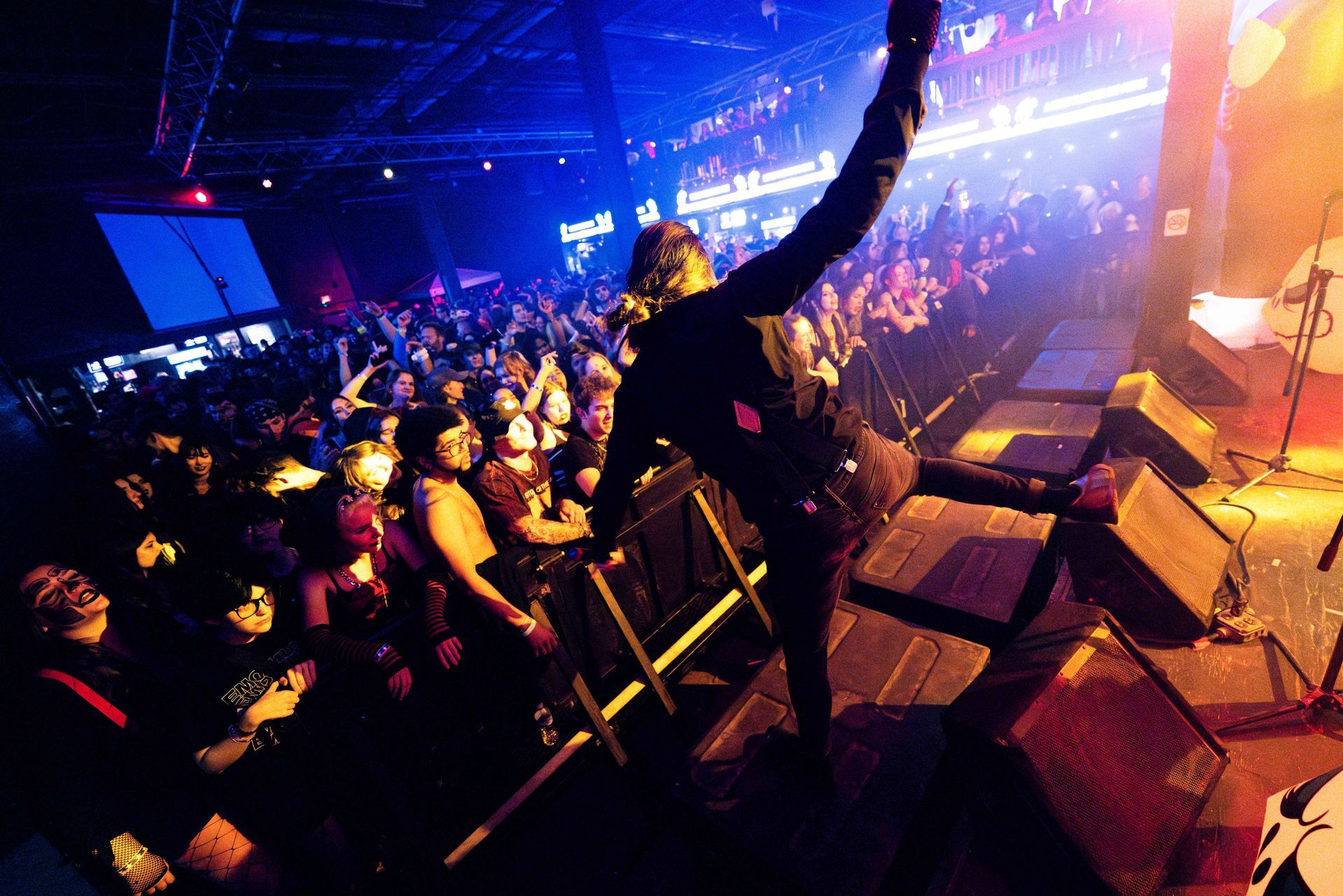 A man is playing a guitar on a stage in front of a crowd.