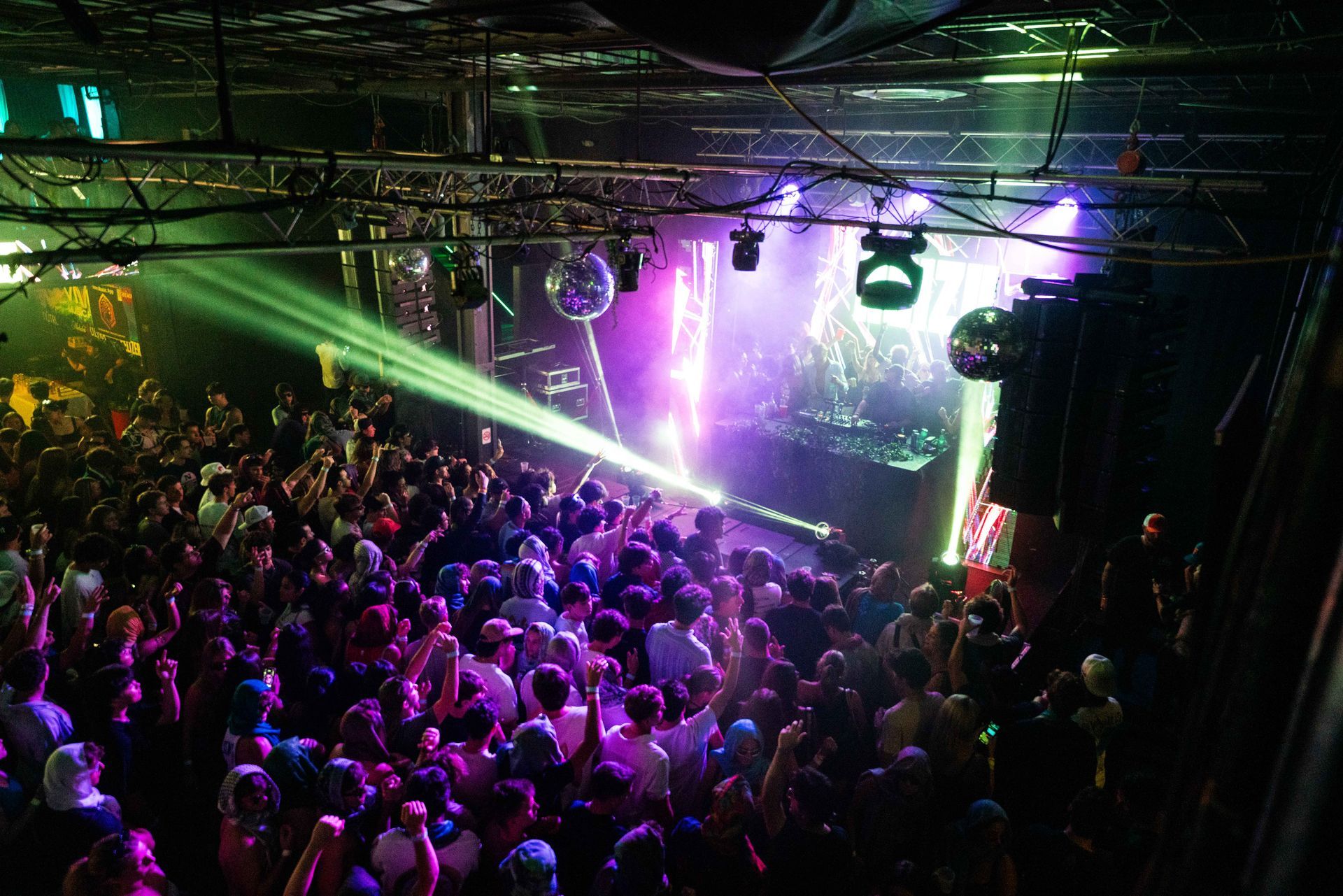 A crowd of people at a concert with purple lights