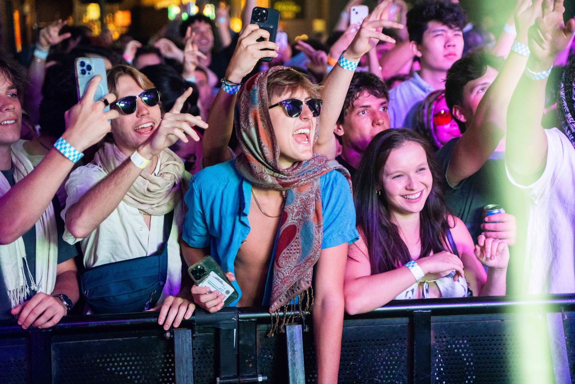 A crowd of people are standing in front of a stage at a concert.
