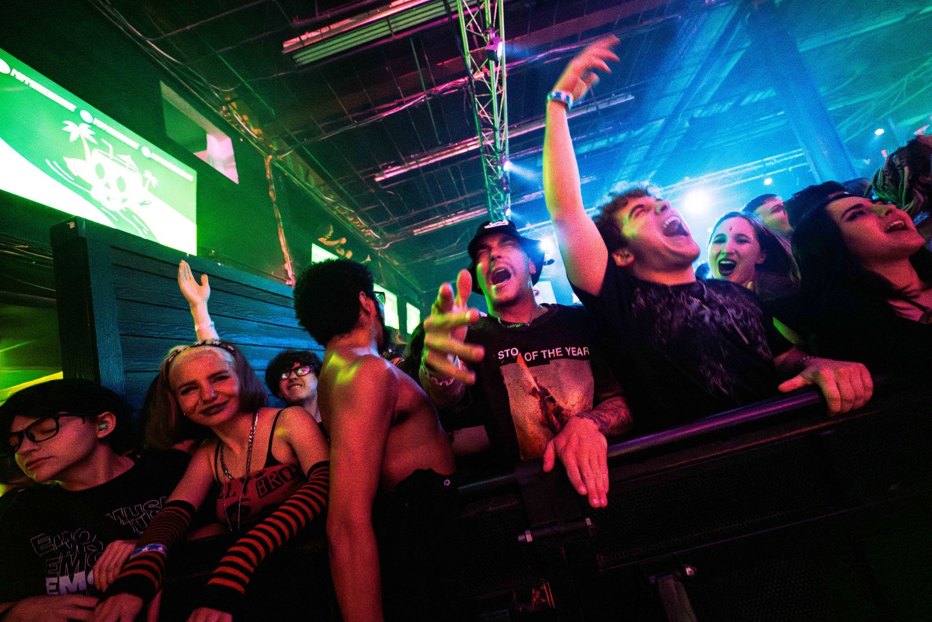 A crowd of people are watching a concert in a dark room.