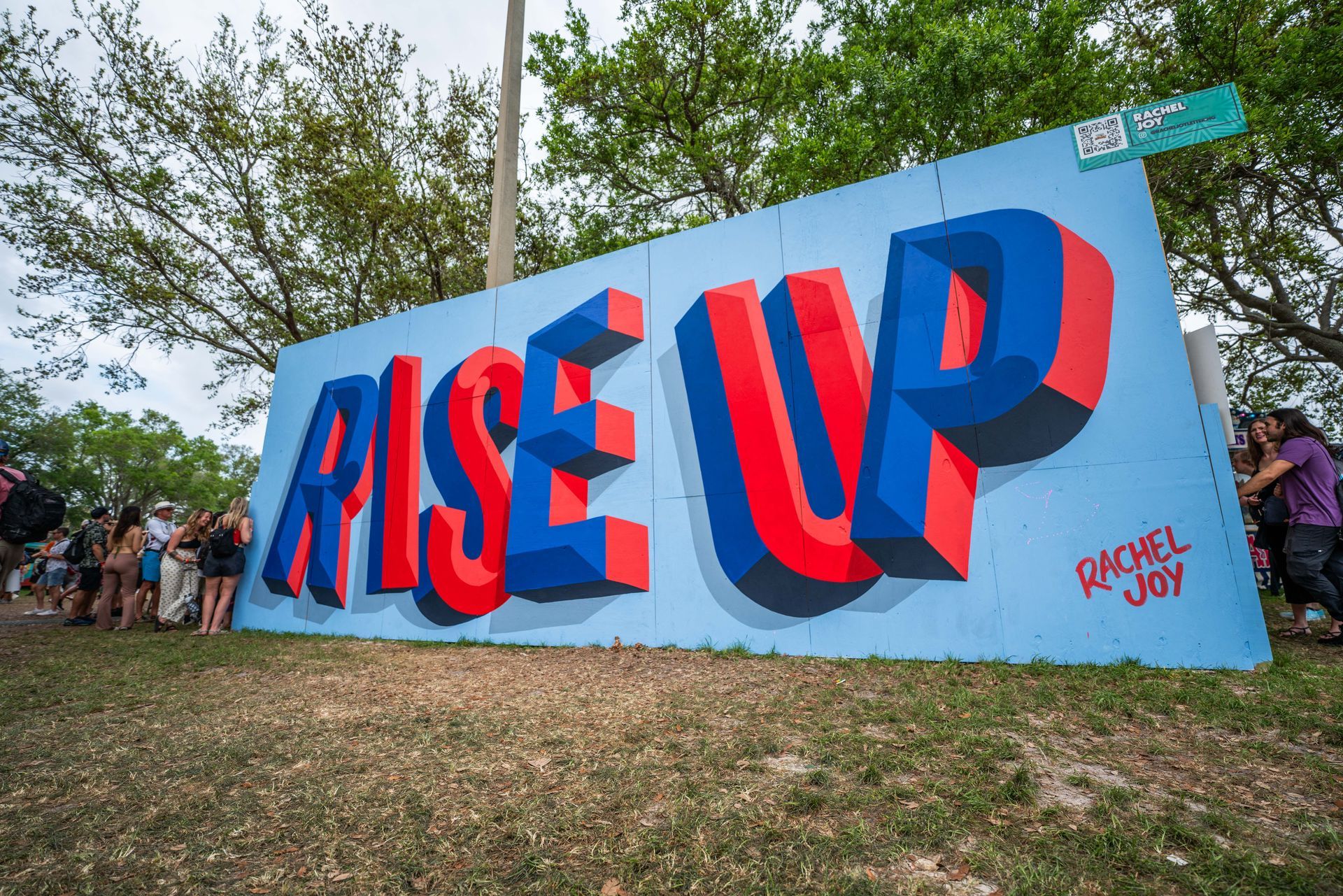 A large mural on a wall that says rise up.