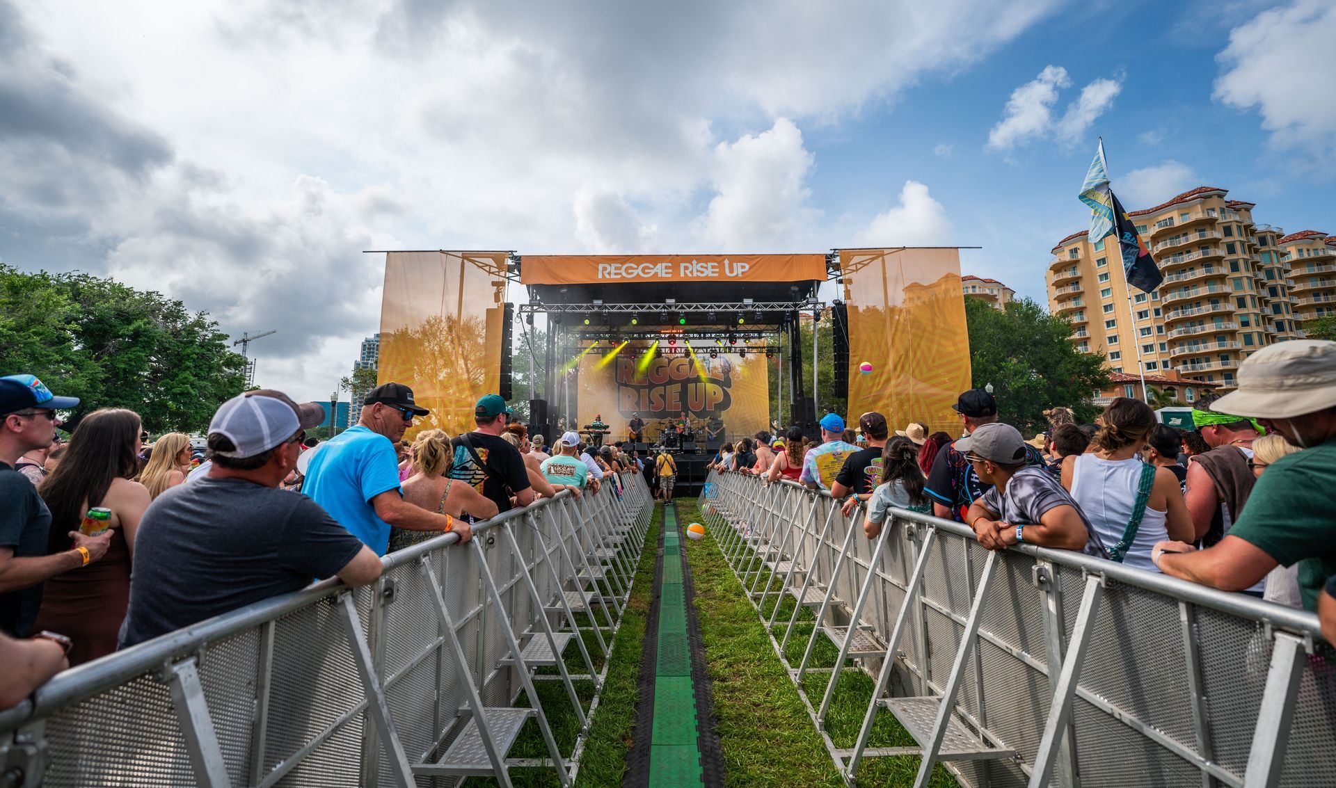 A crowd of people are sitting in front of a stage at a concert.