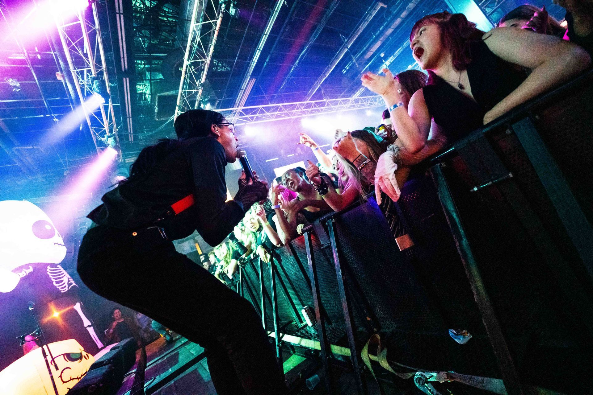 A man singing into a microphone in front of a crowd at a concert