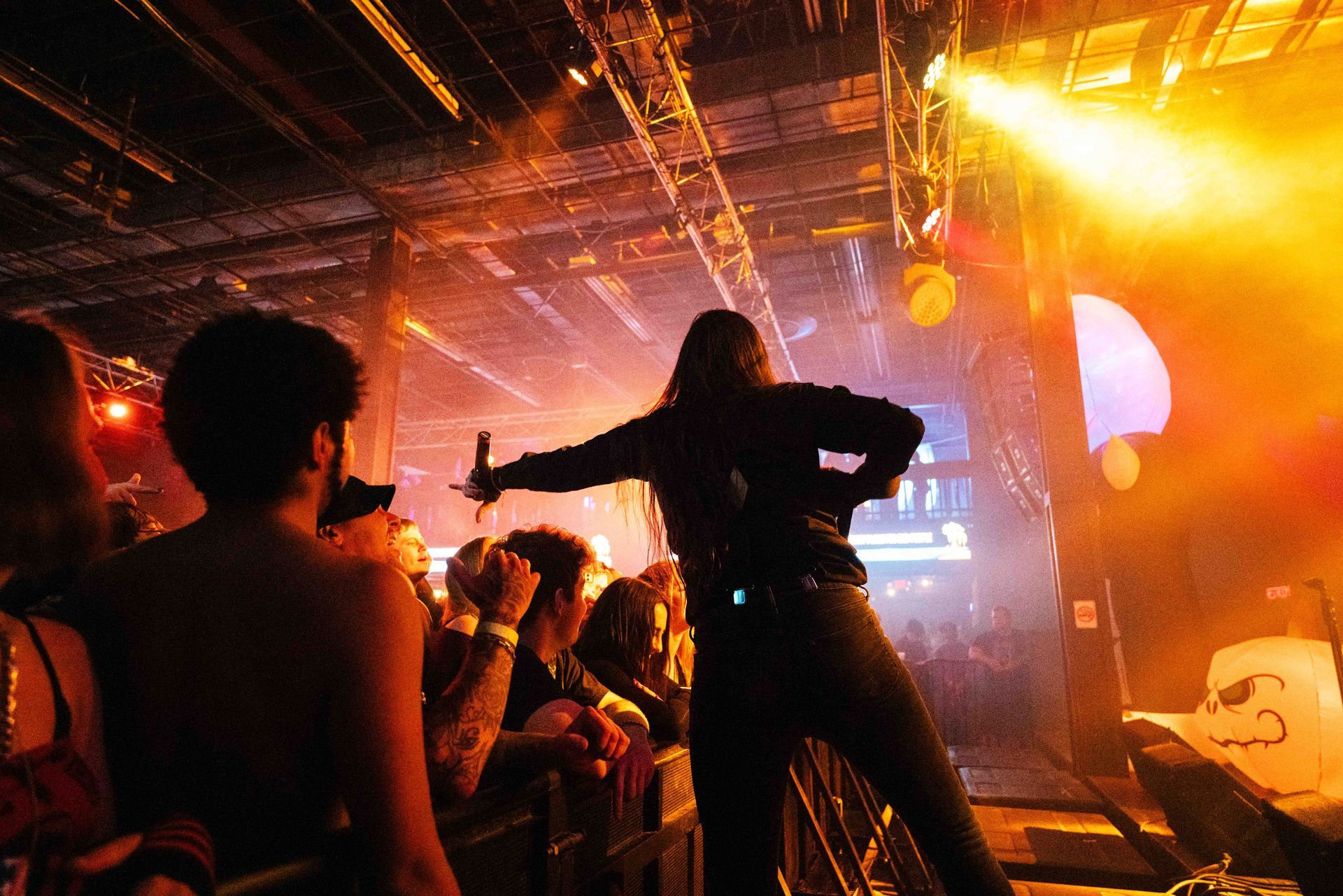 A woman is standing on a stage holding a microphone in front of a crowd.