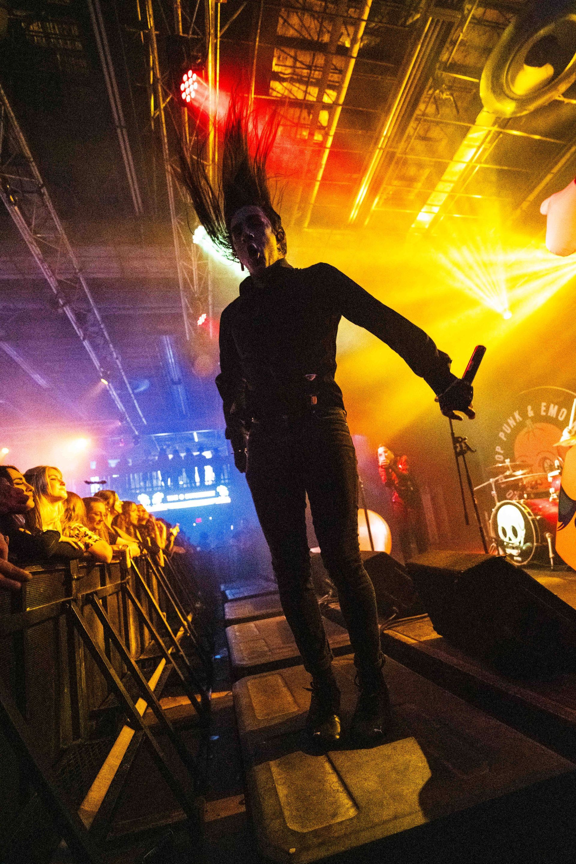A man holding a microphone on a stage in front of a crowd