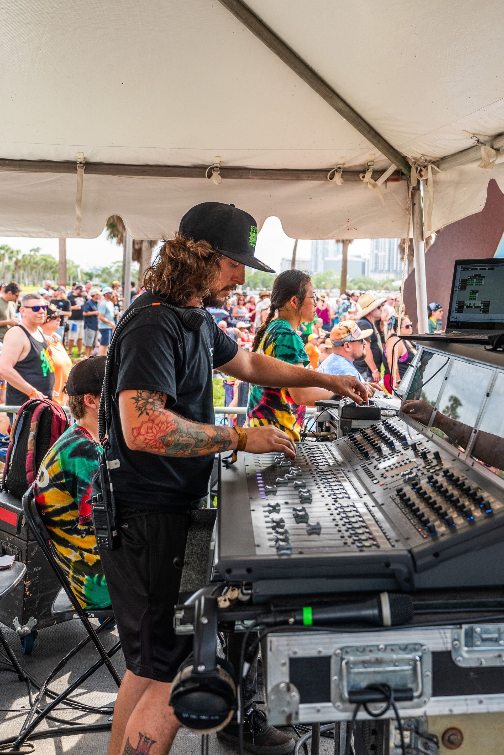A man is standing in front of a mixer in a tent.