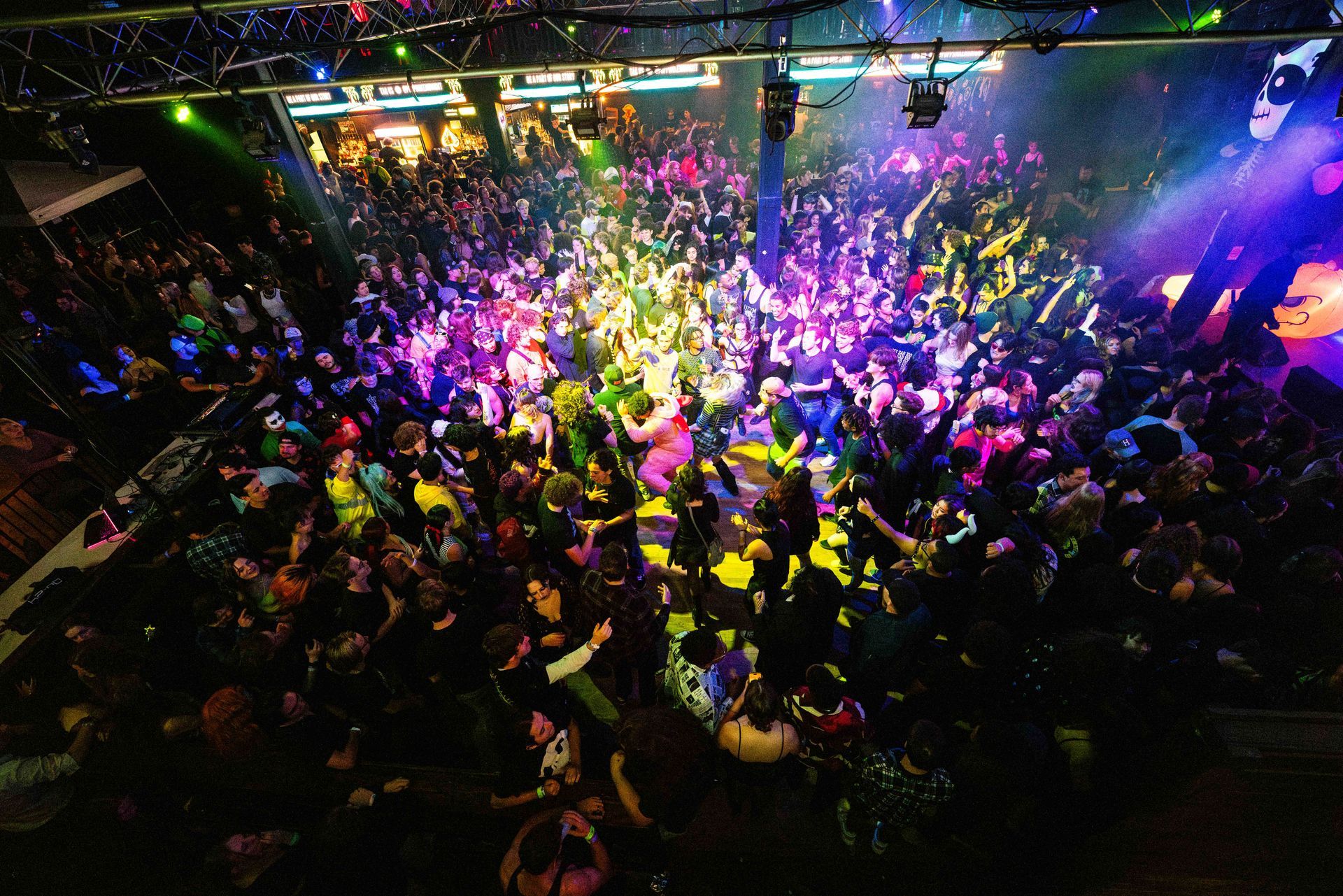 A large crowd of people are dancing in a club