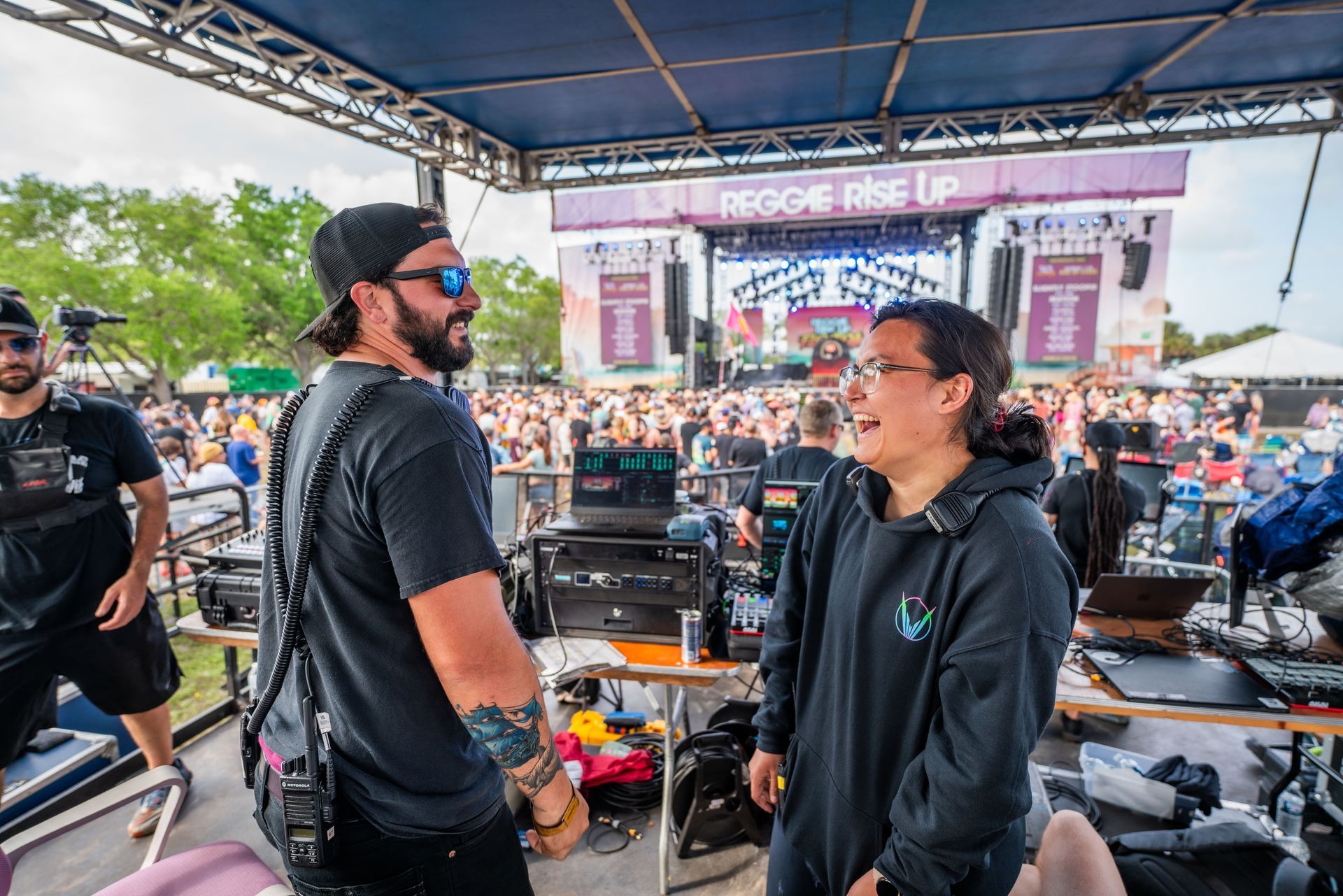 A man and a woman are talking in front of a crowd at a concert.