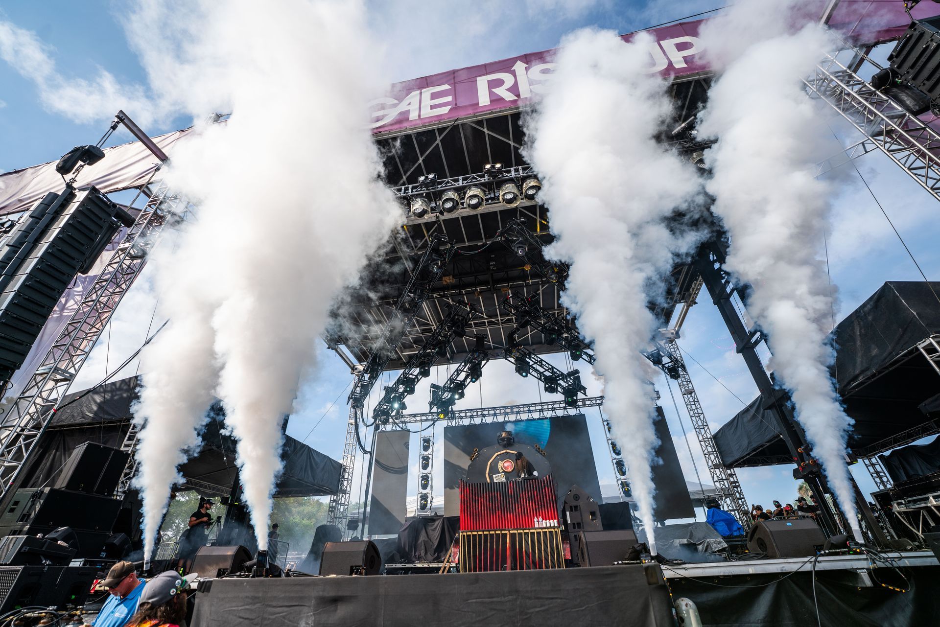 A man is standing on a stage with smoke coming out of it.