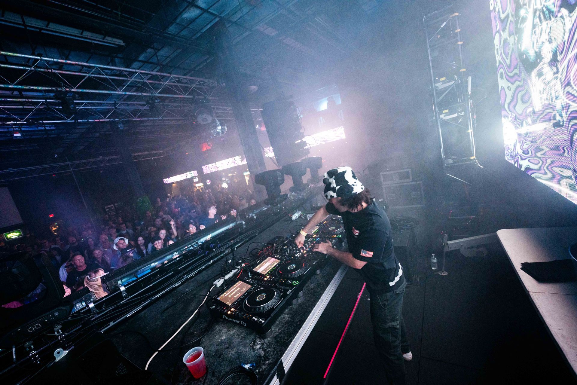 A dj is playing music on a stage in front of a crowd.