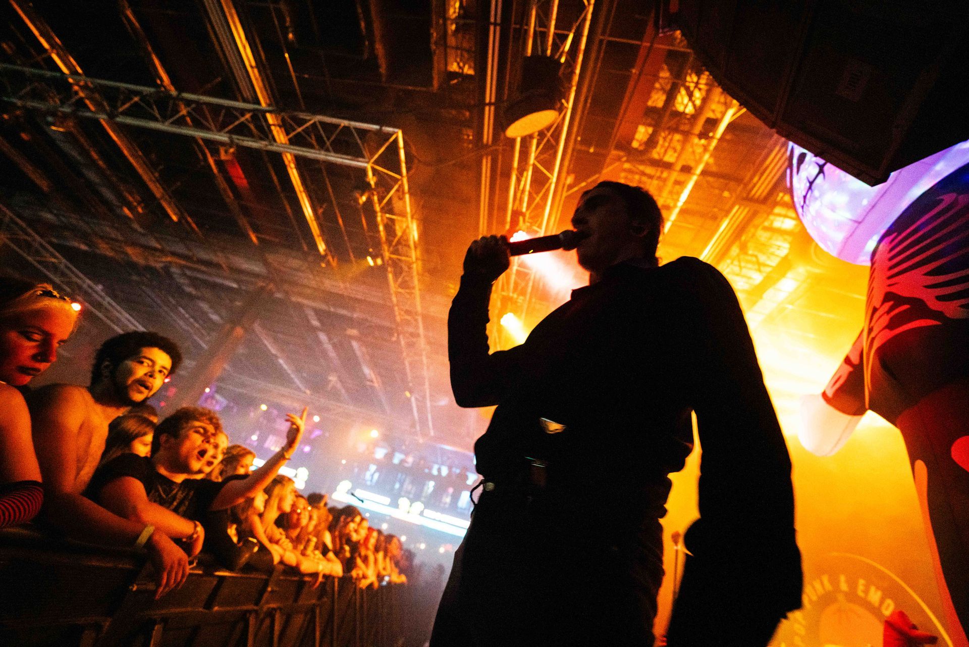 A man singing into a microphone in front of a crowd at a concert