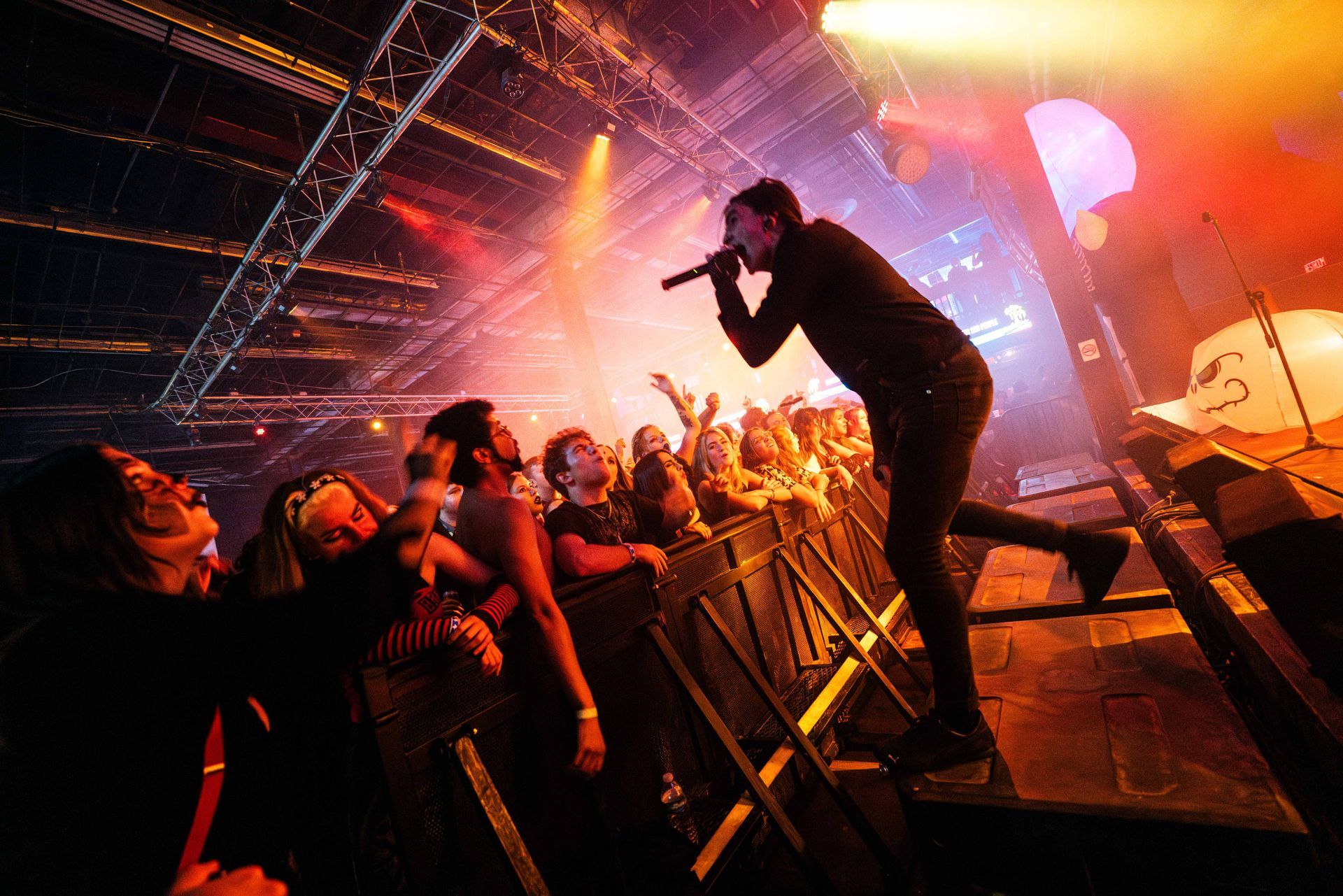 A man is singing into a microphone in front of a crowd at a concert.