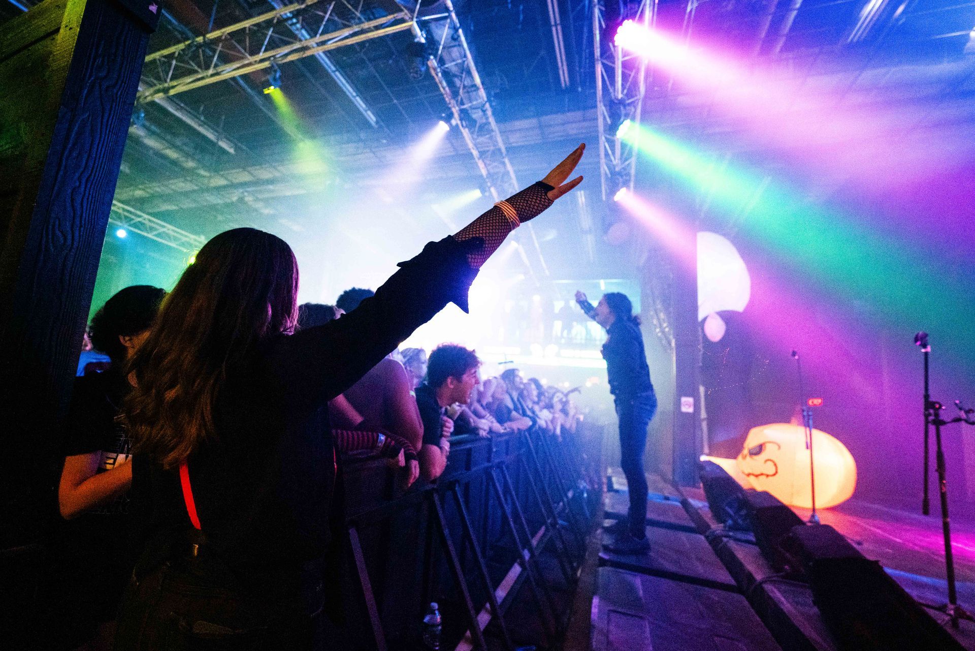 A woman is standing in front of a crowd at a concert.