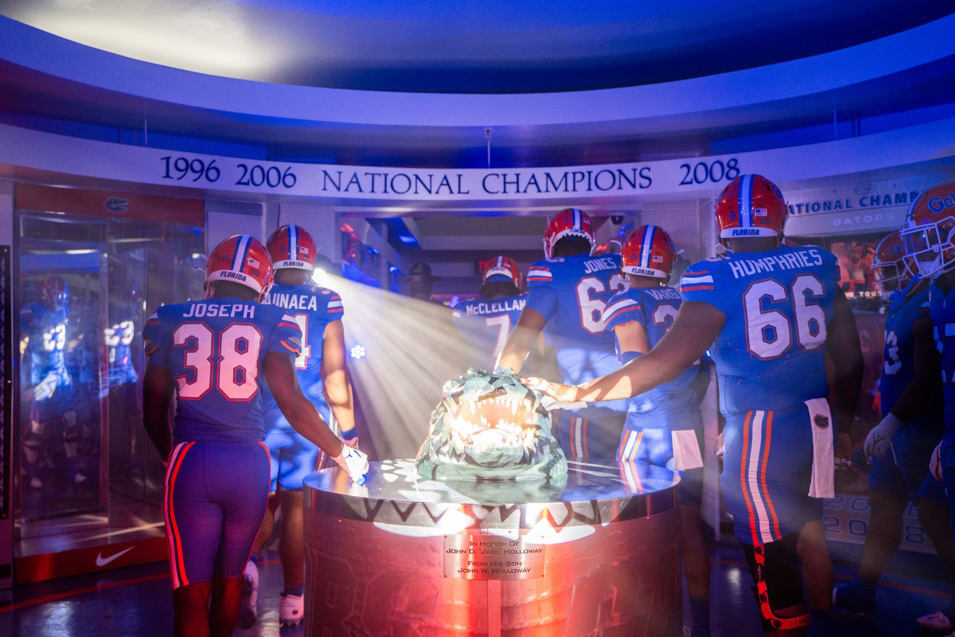 A group of football players are standing around a table with a sign that says national champions.