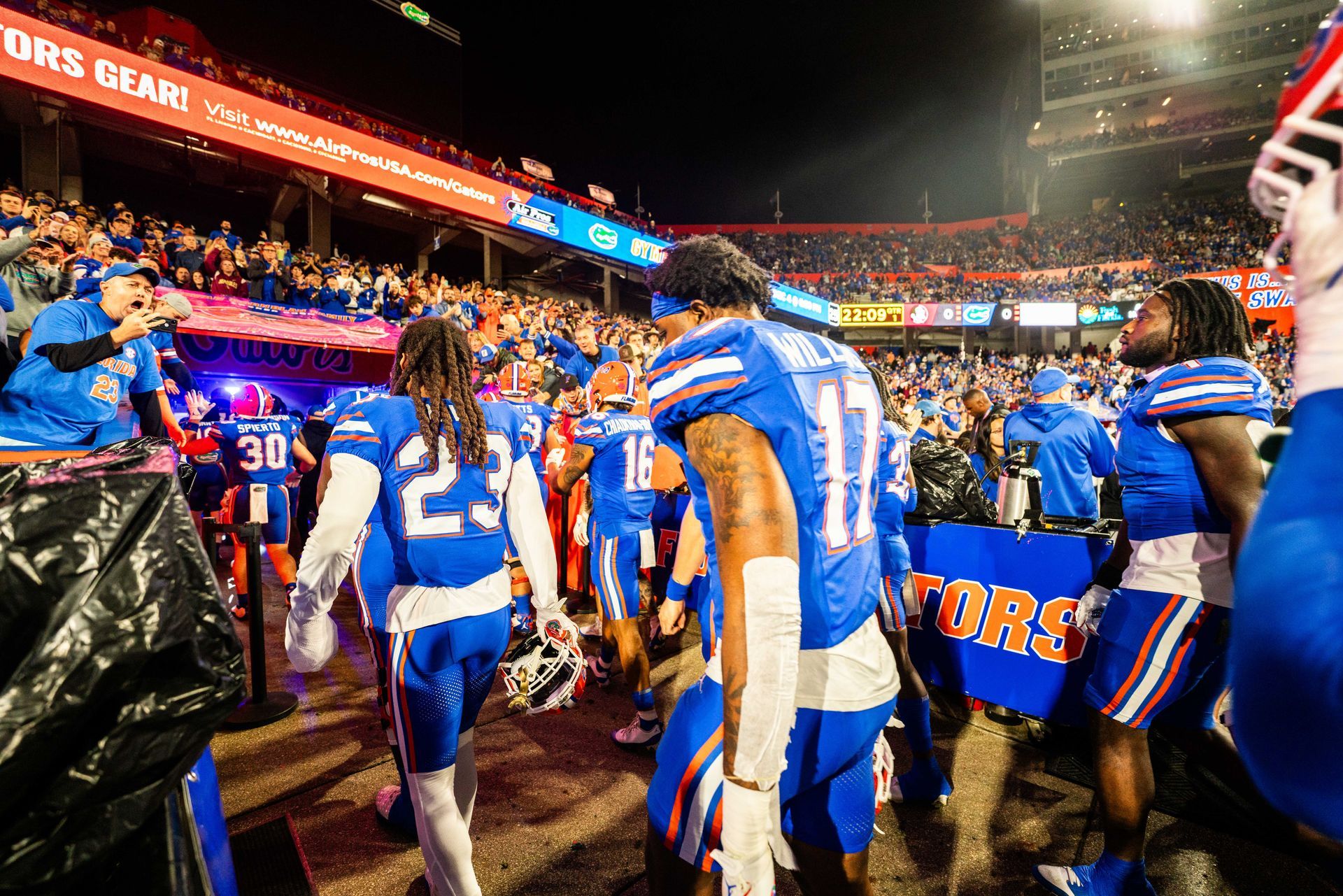 A group of football players are walking off the field.