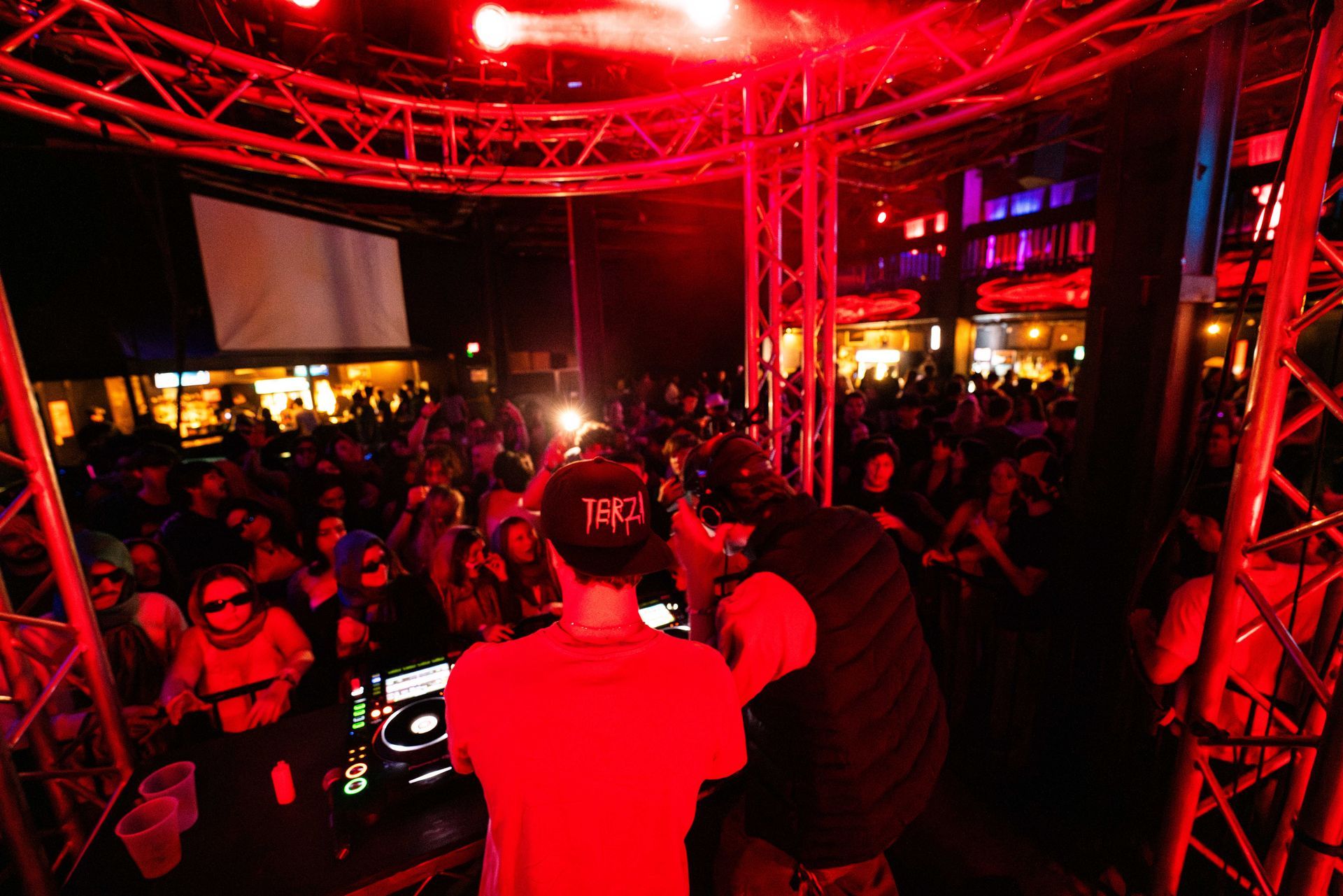 A dj is playing music in front of a crowd at a party.