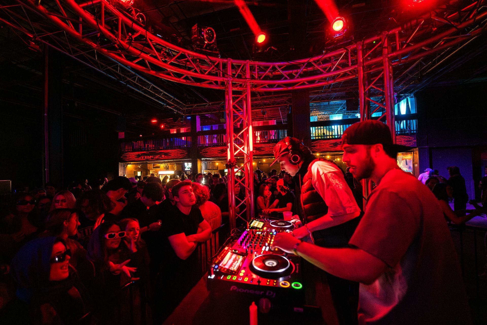 Two men are playing music on a stage in front of a crowd.