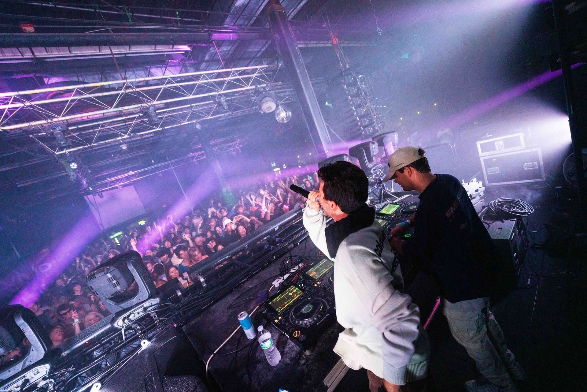 Two men are standing in front of a crowd at a concert.