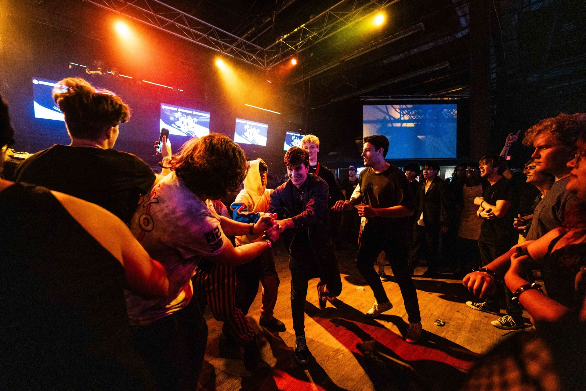 A group of people are dancing on a stage at a concert.