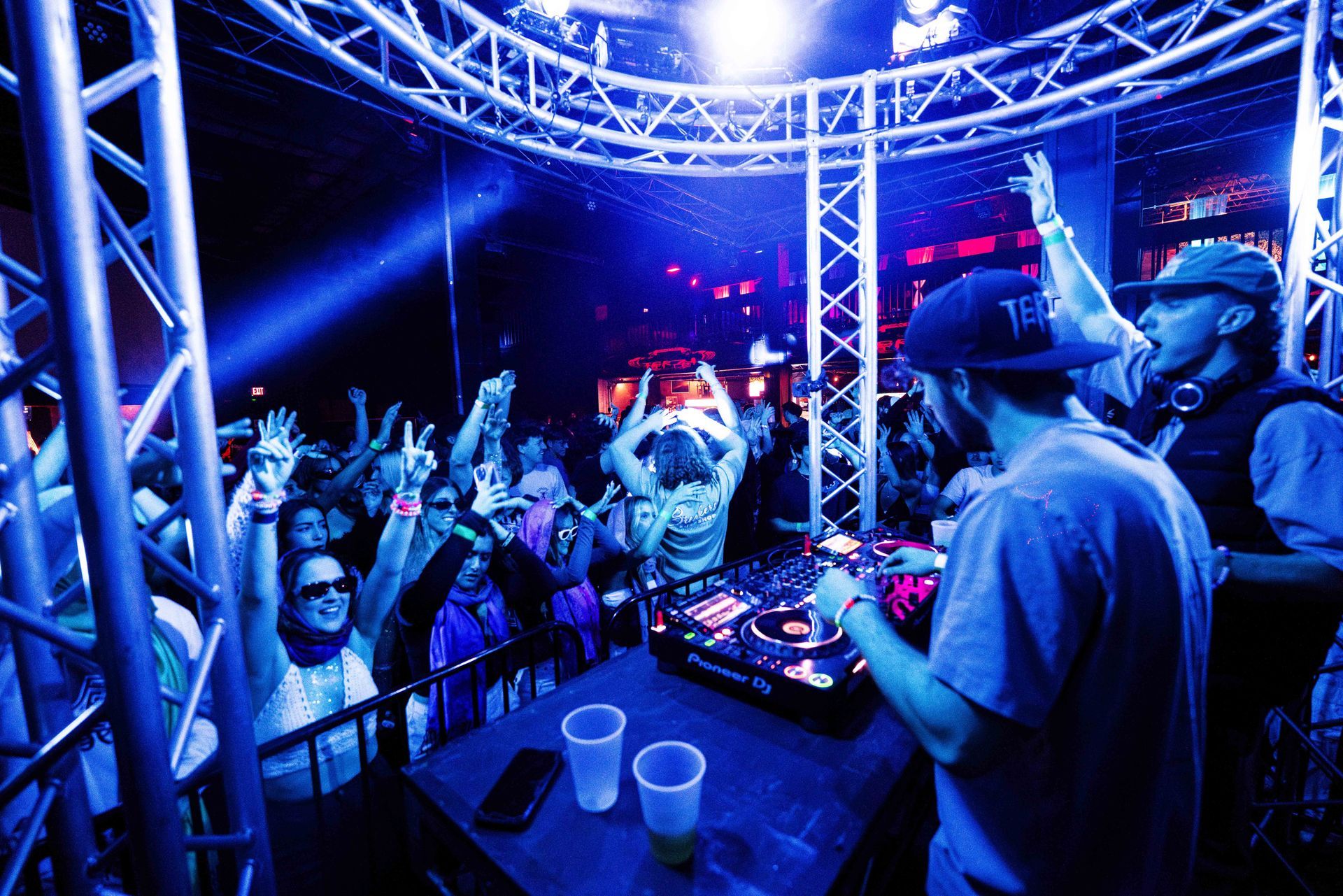A dj is playing music in front of a crowd at a party.
