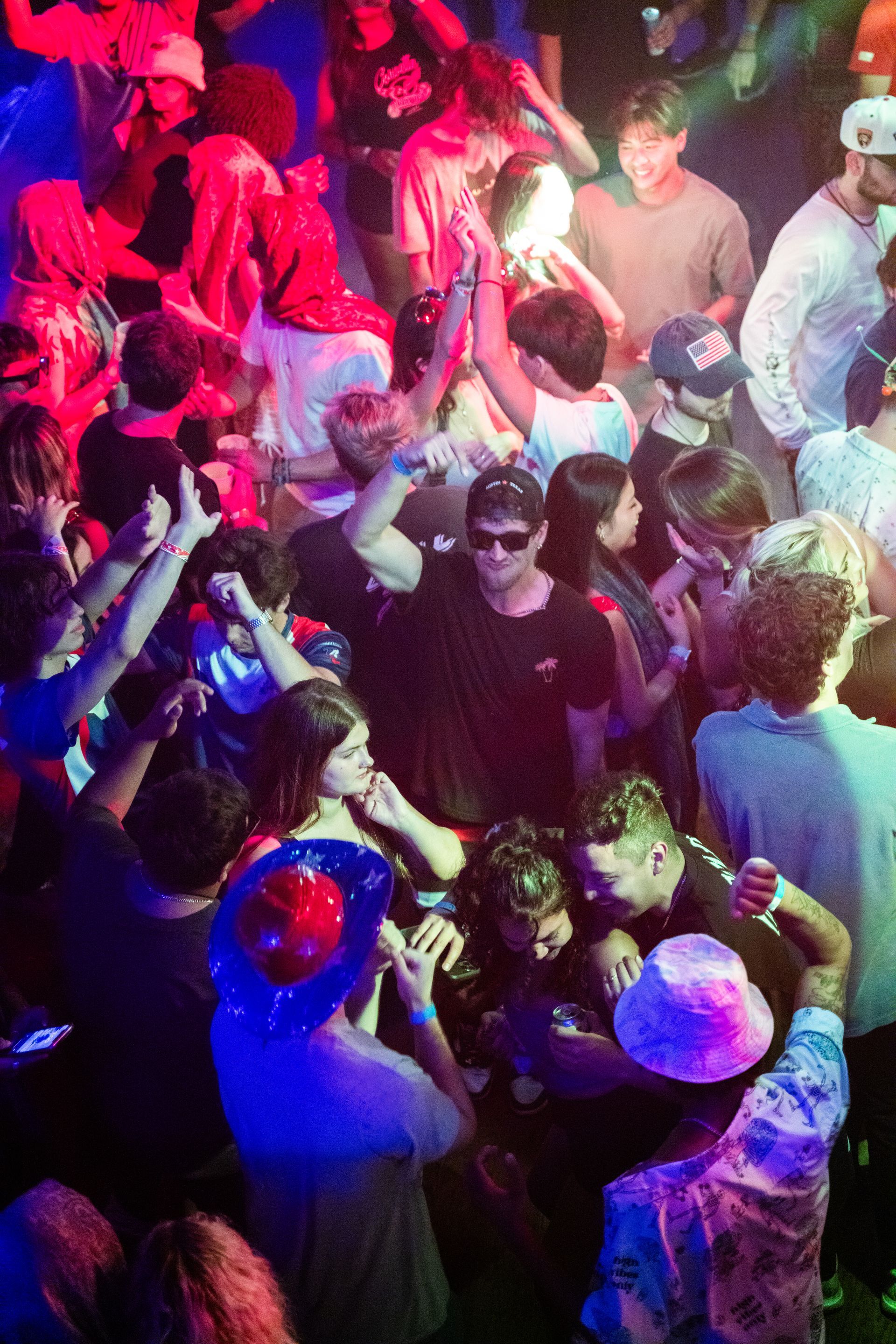 A crowd of people are dancing in a dark room