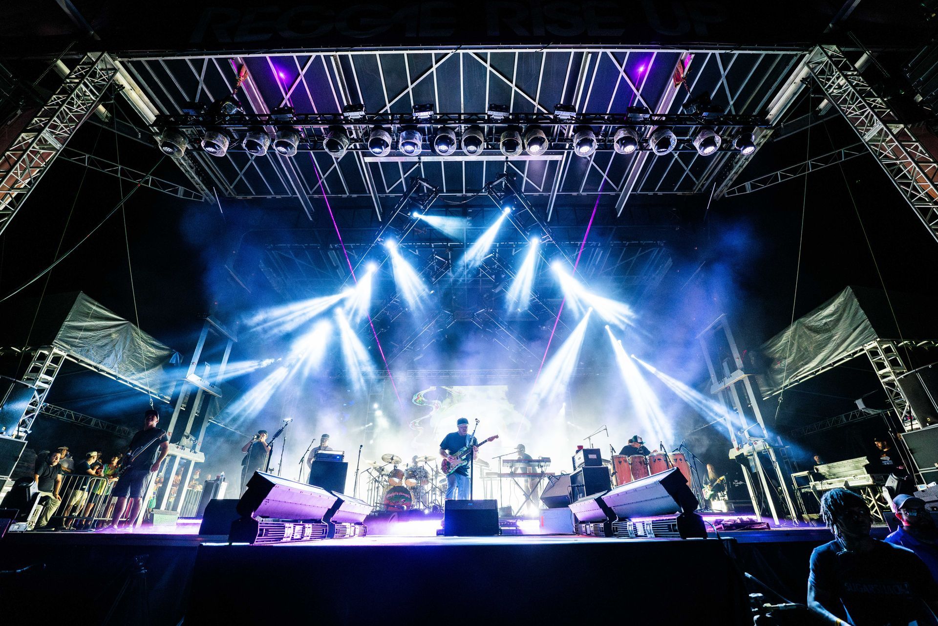A group of people are playing instruments on a stage at a concert.