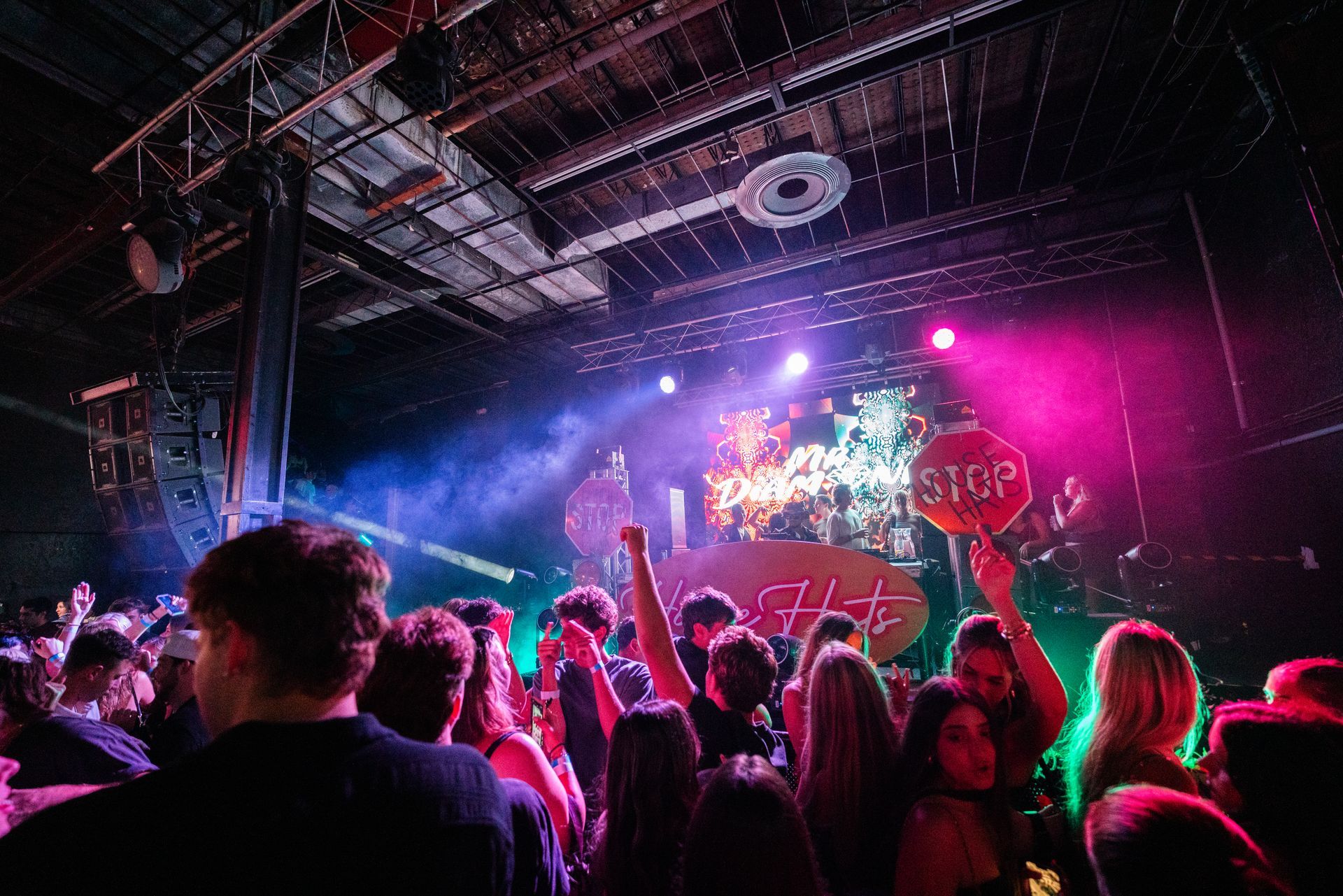 A crowd of people are standing in front of a stage at a concert.