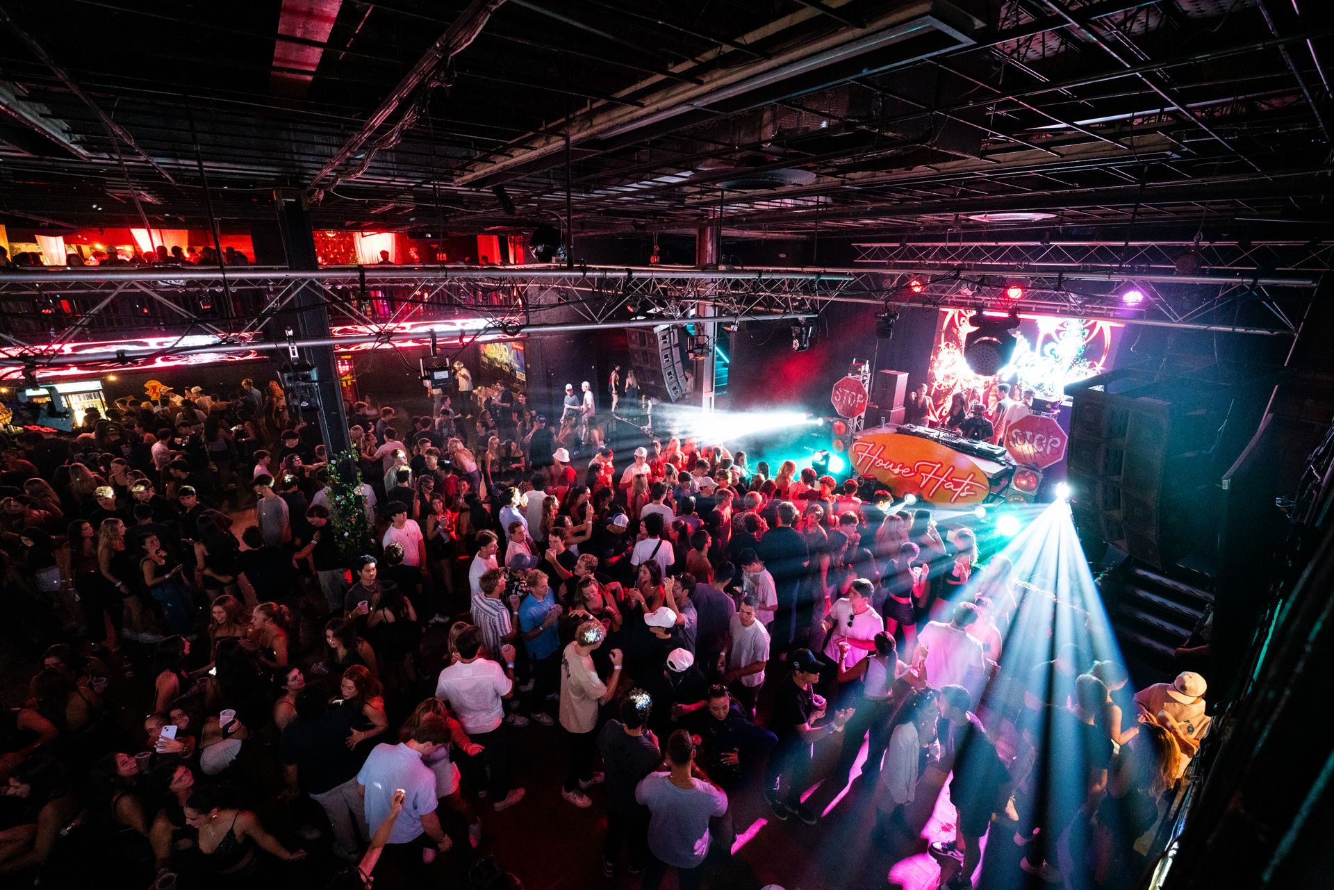 A large crowd of people are dancing in a club.