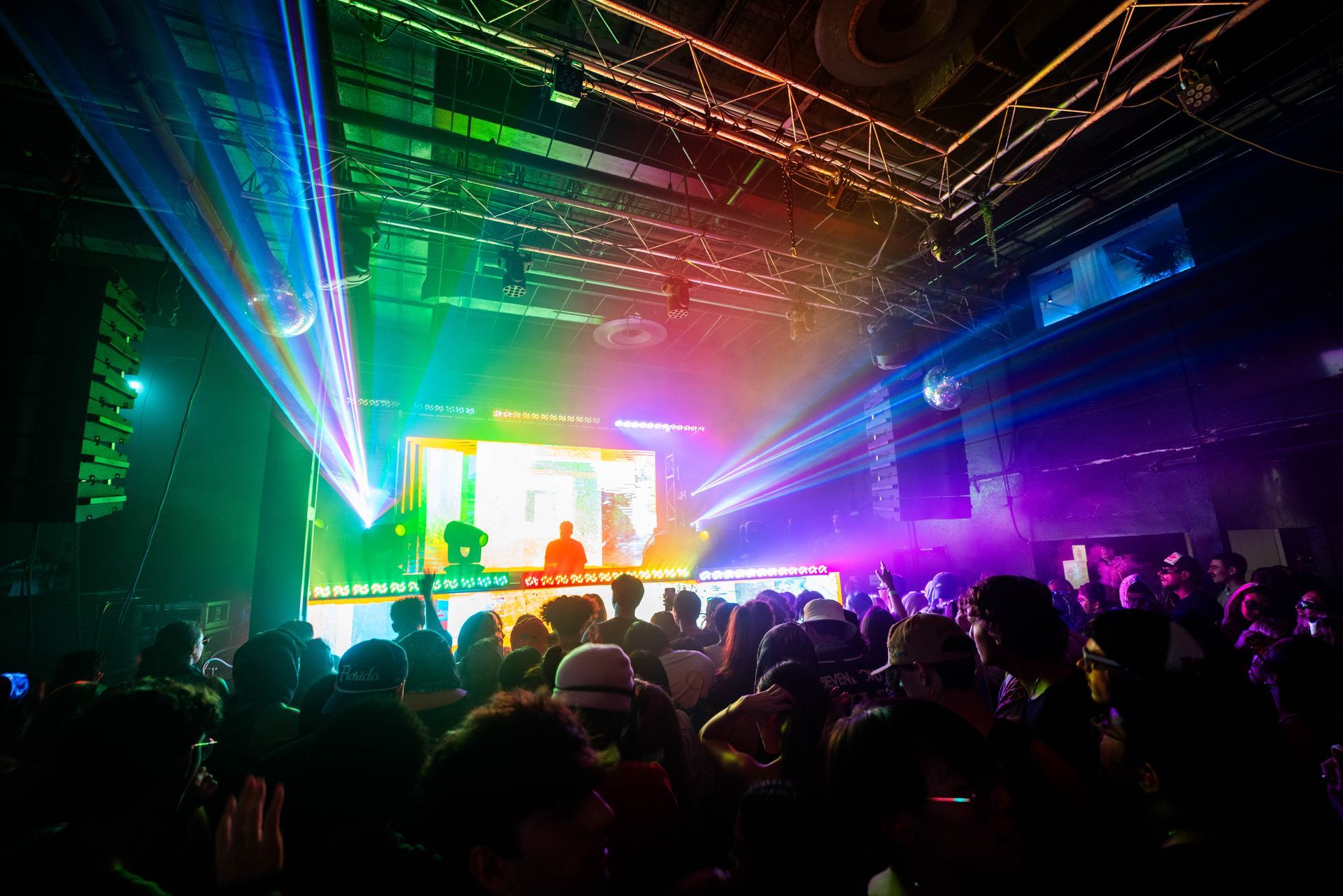 A crowd of people are standing in front of a stage at a concert.