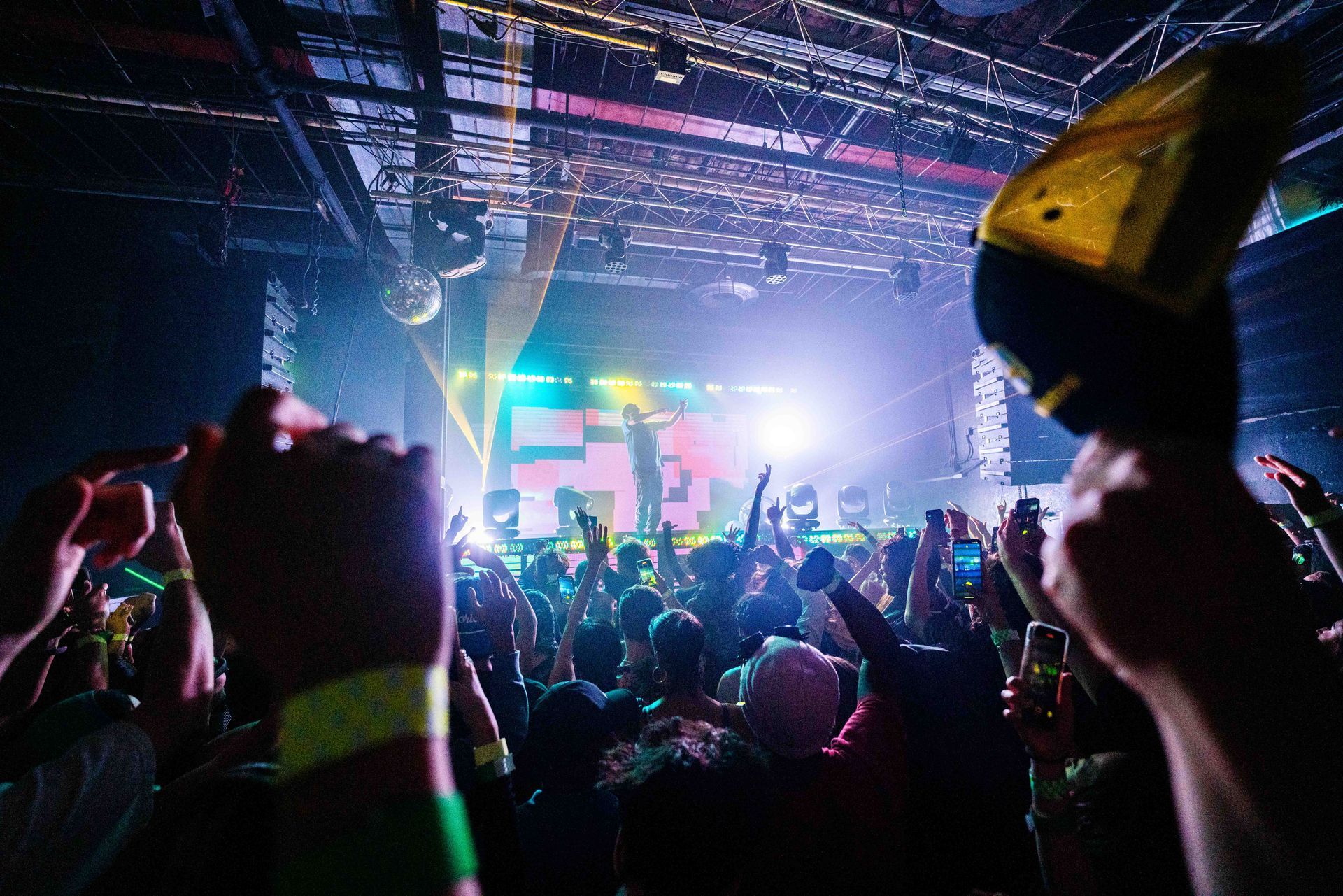 A crowd of people are standing in front of a stage at a concert.
