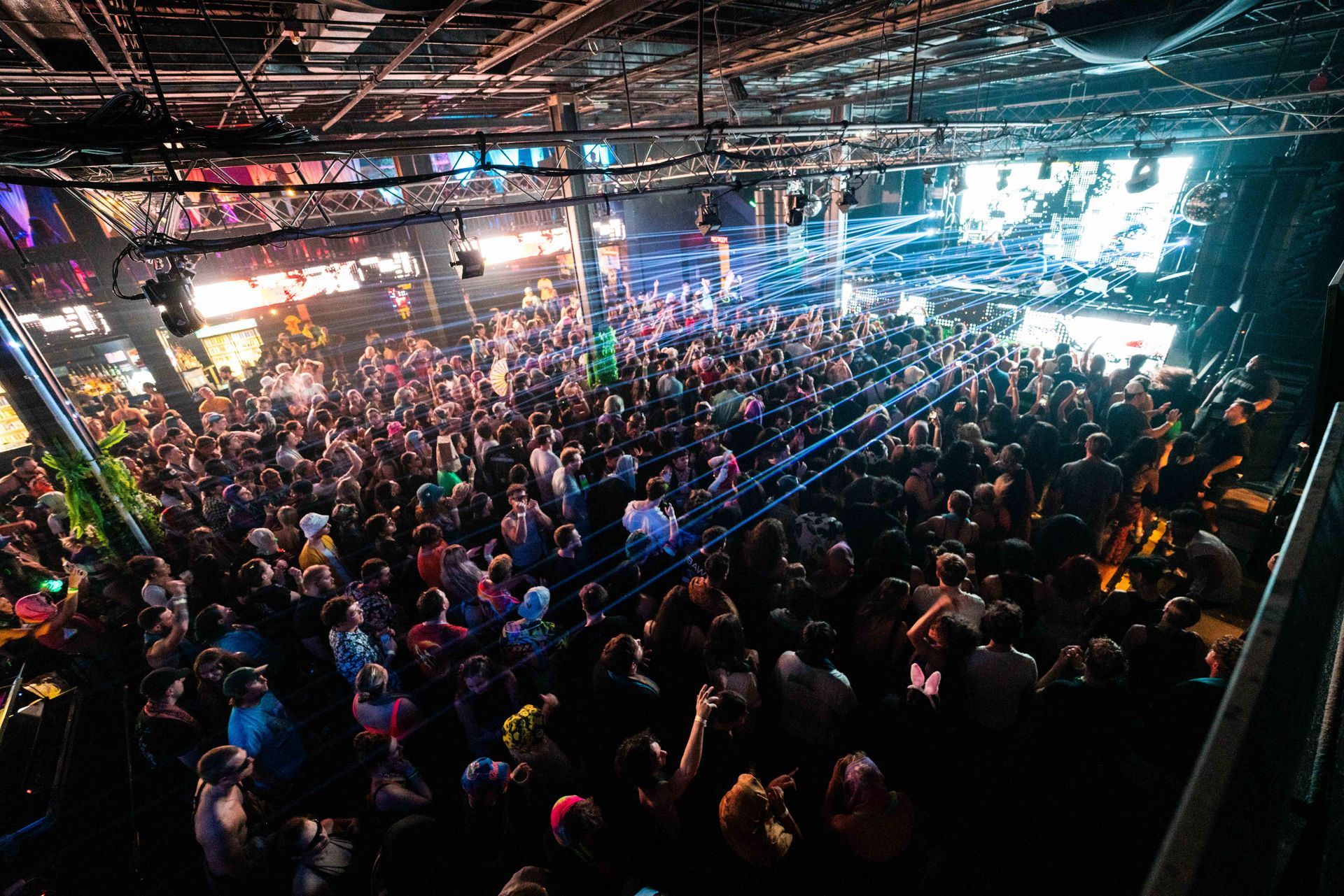 A large crowd of people are gathered in a large room at a concert.