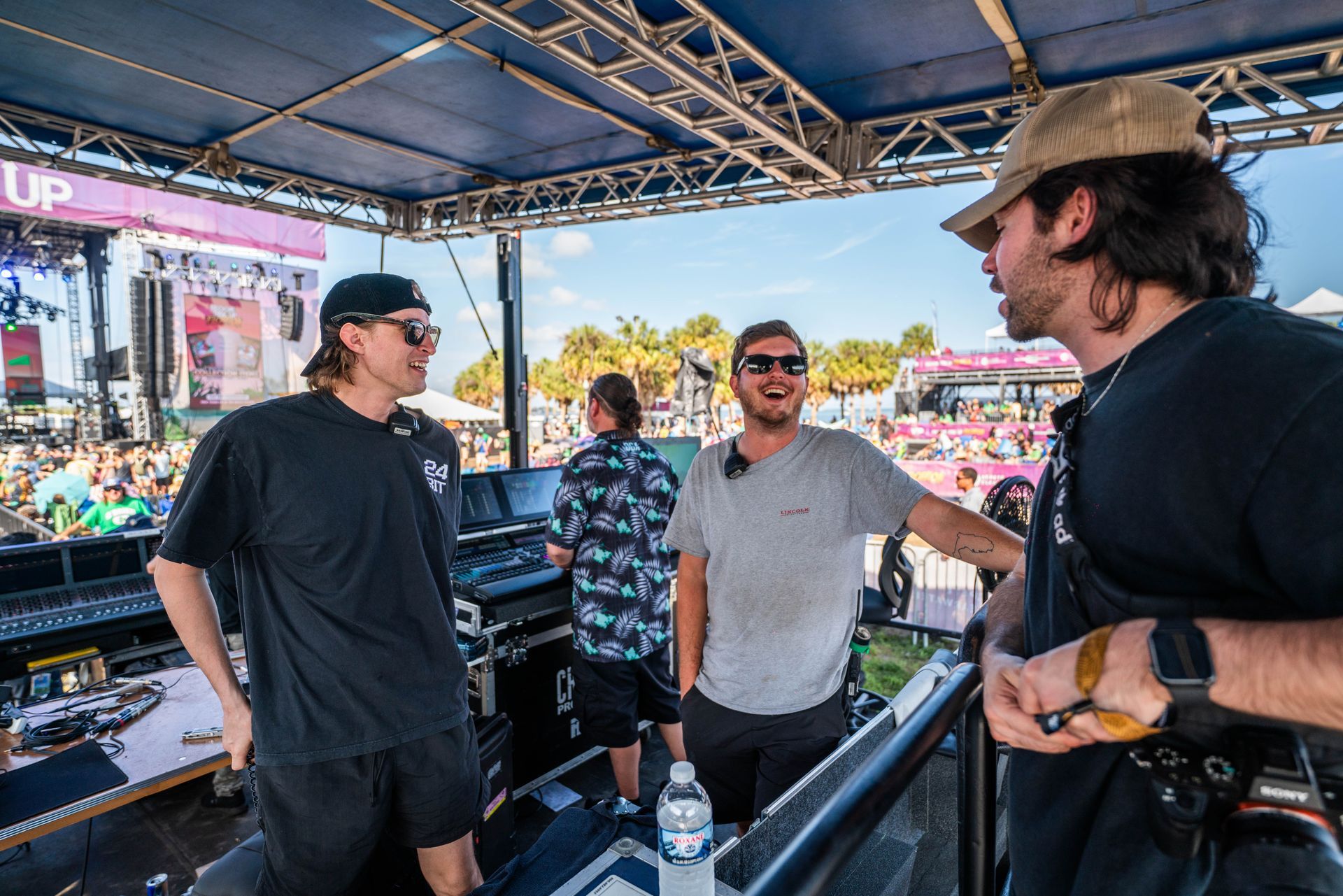 A group of men are standing in front of a stage talking to each other.