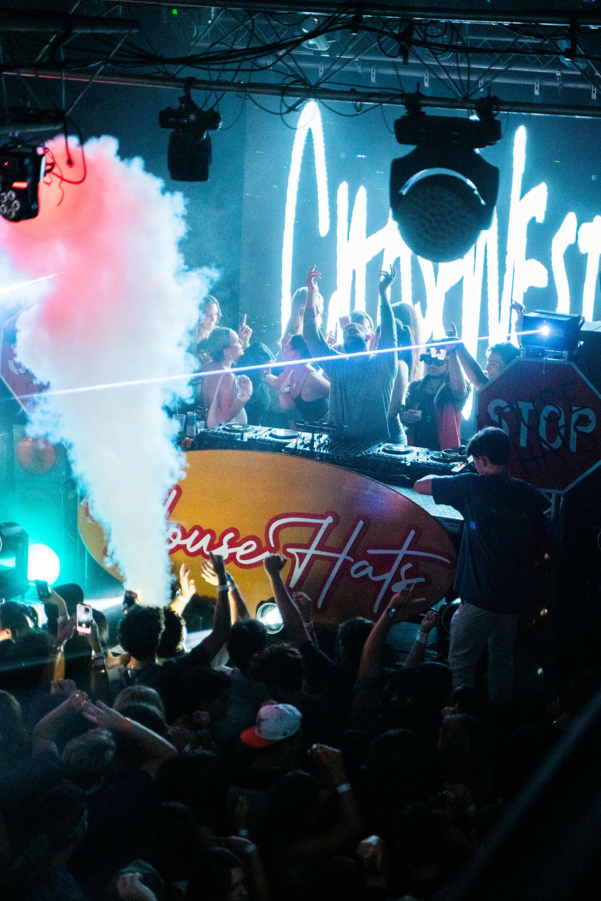 A crowd of people at a concert with a stop sign in the background