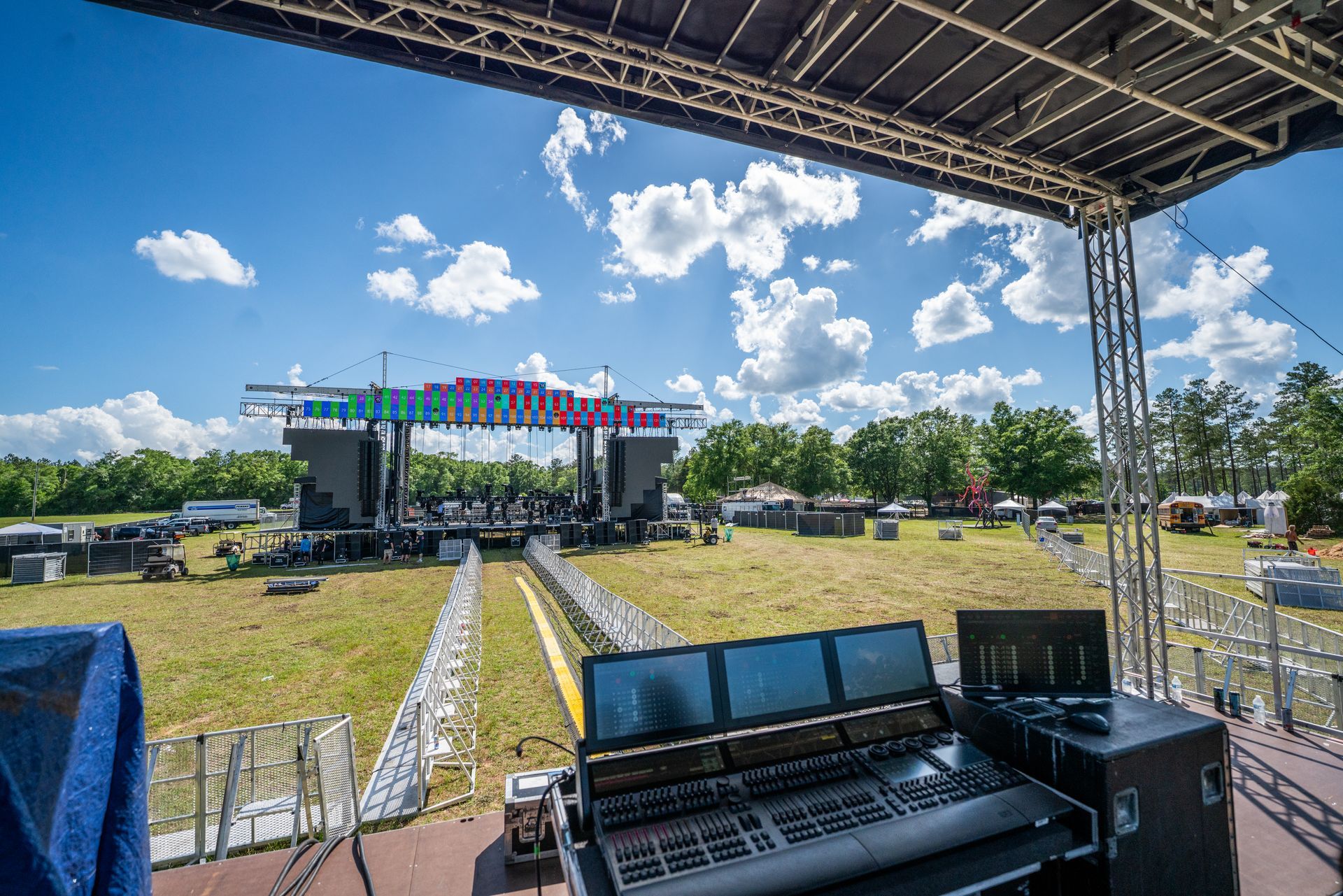 A large stage is being set up for a concert in a field.