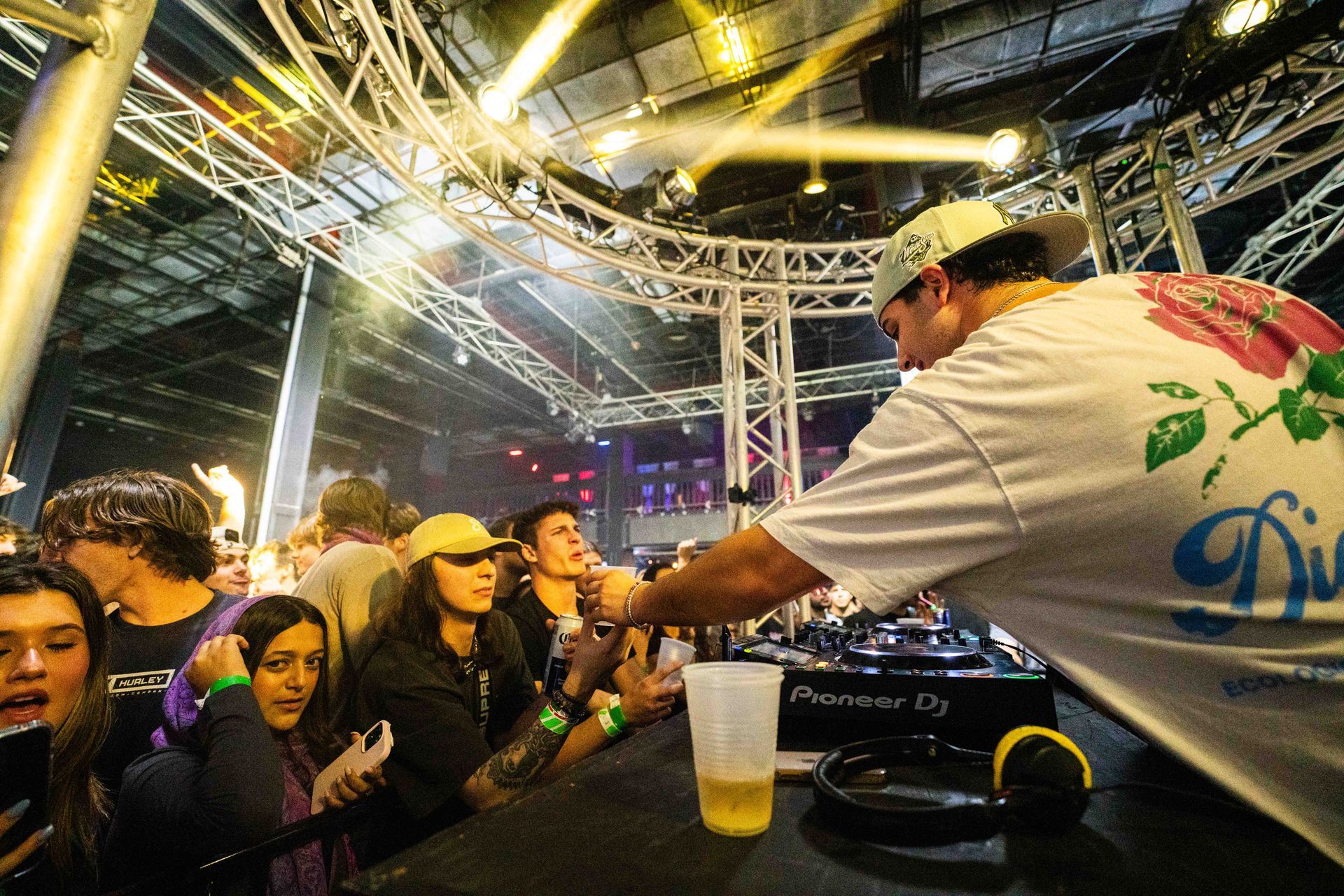 A dj is playing music in front of a crowd of people at a party.